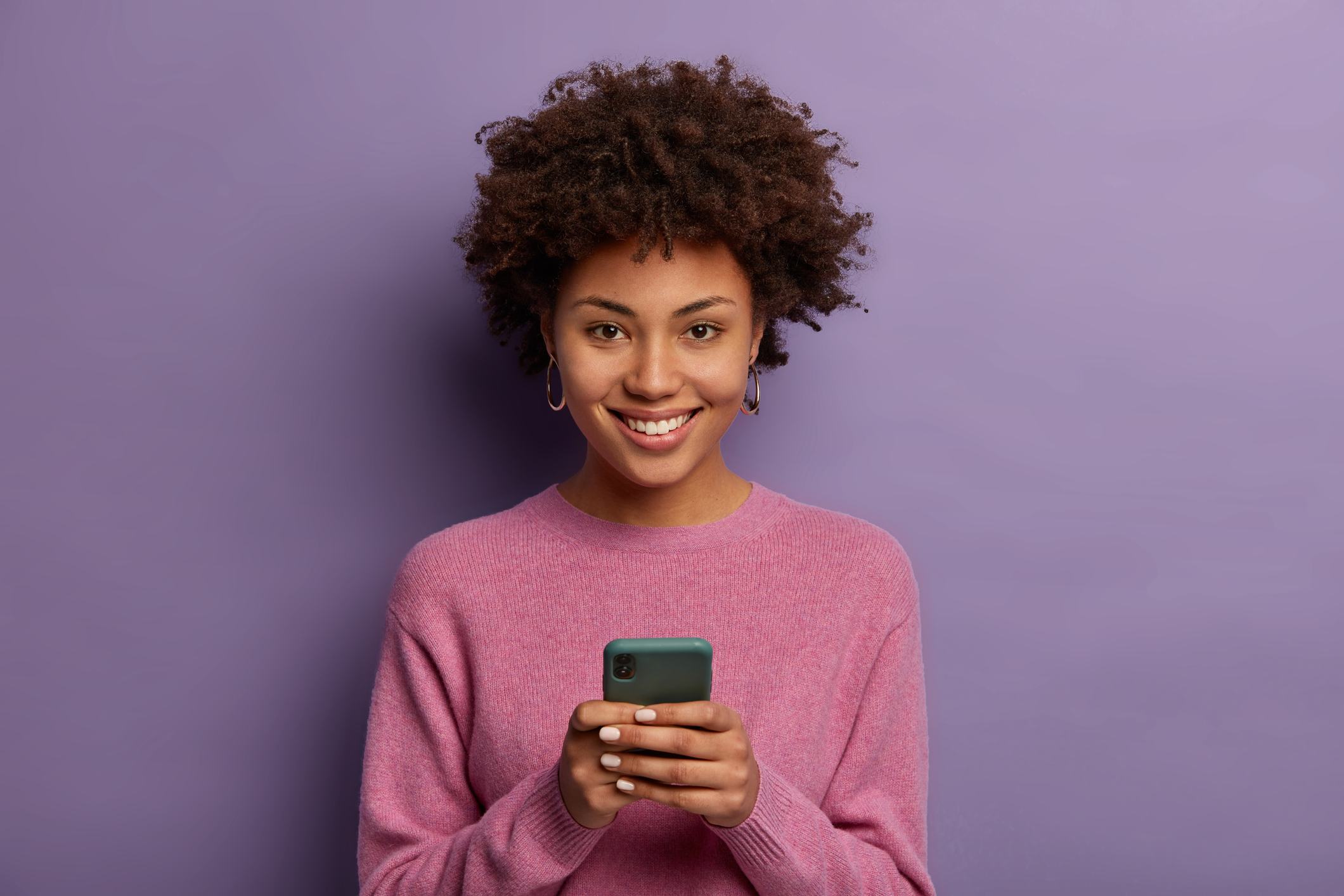 Person smiling while using a smartphone.