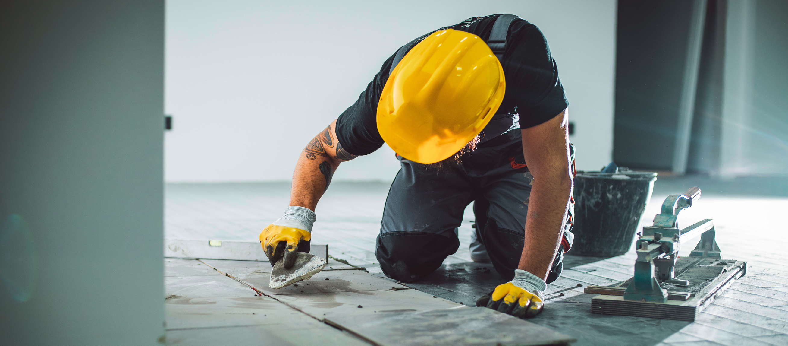 Person wearing hardhat and doing interior construction work.