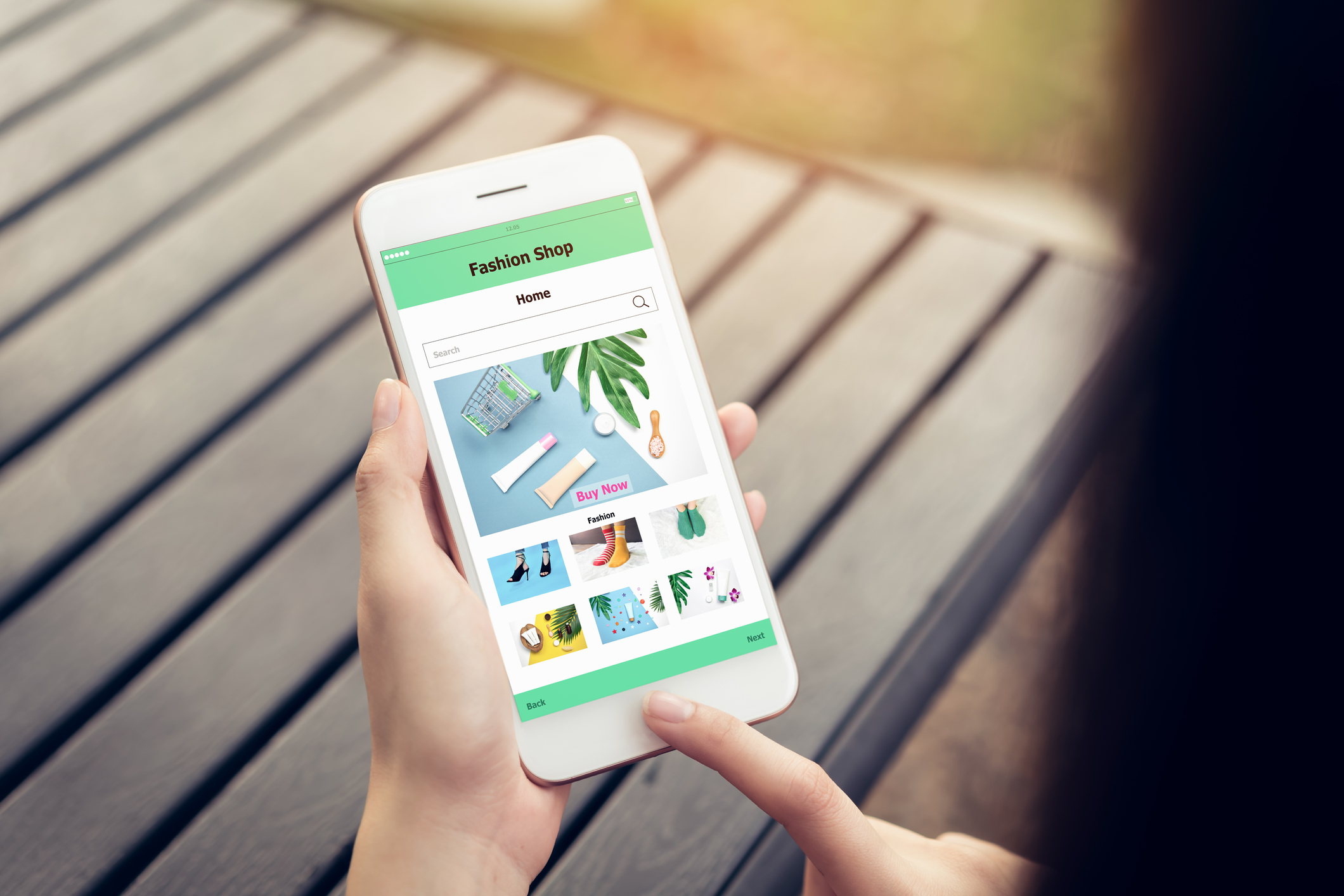 Person's hands holding a cell phone with screen showing  "Fashion Shop."