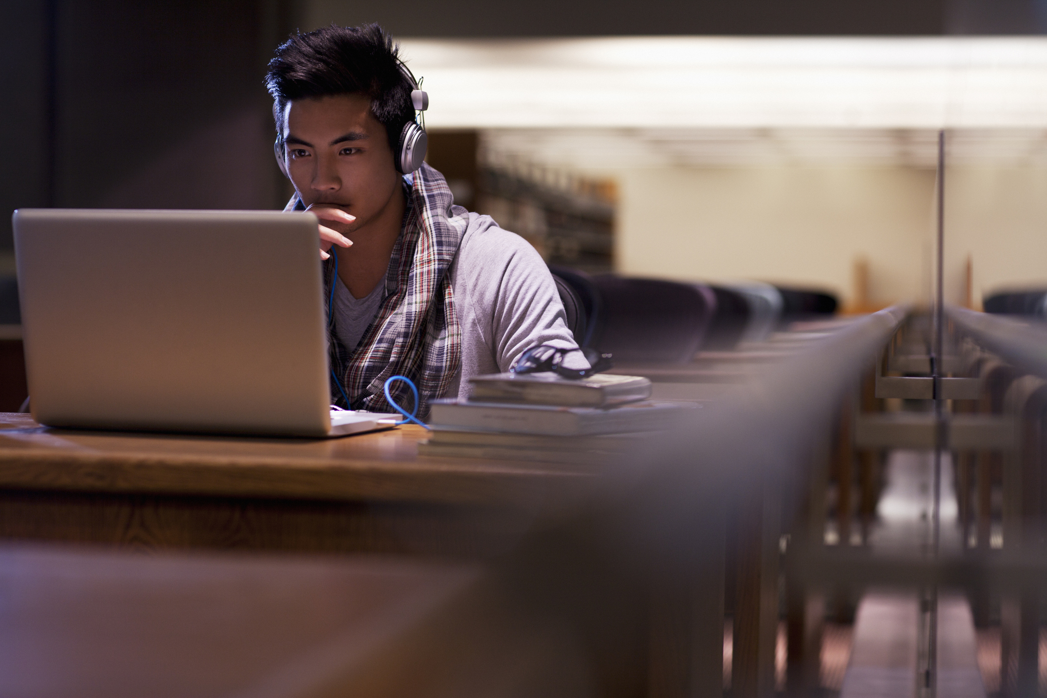A person doing homework on a laptop in the library.