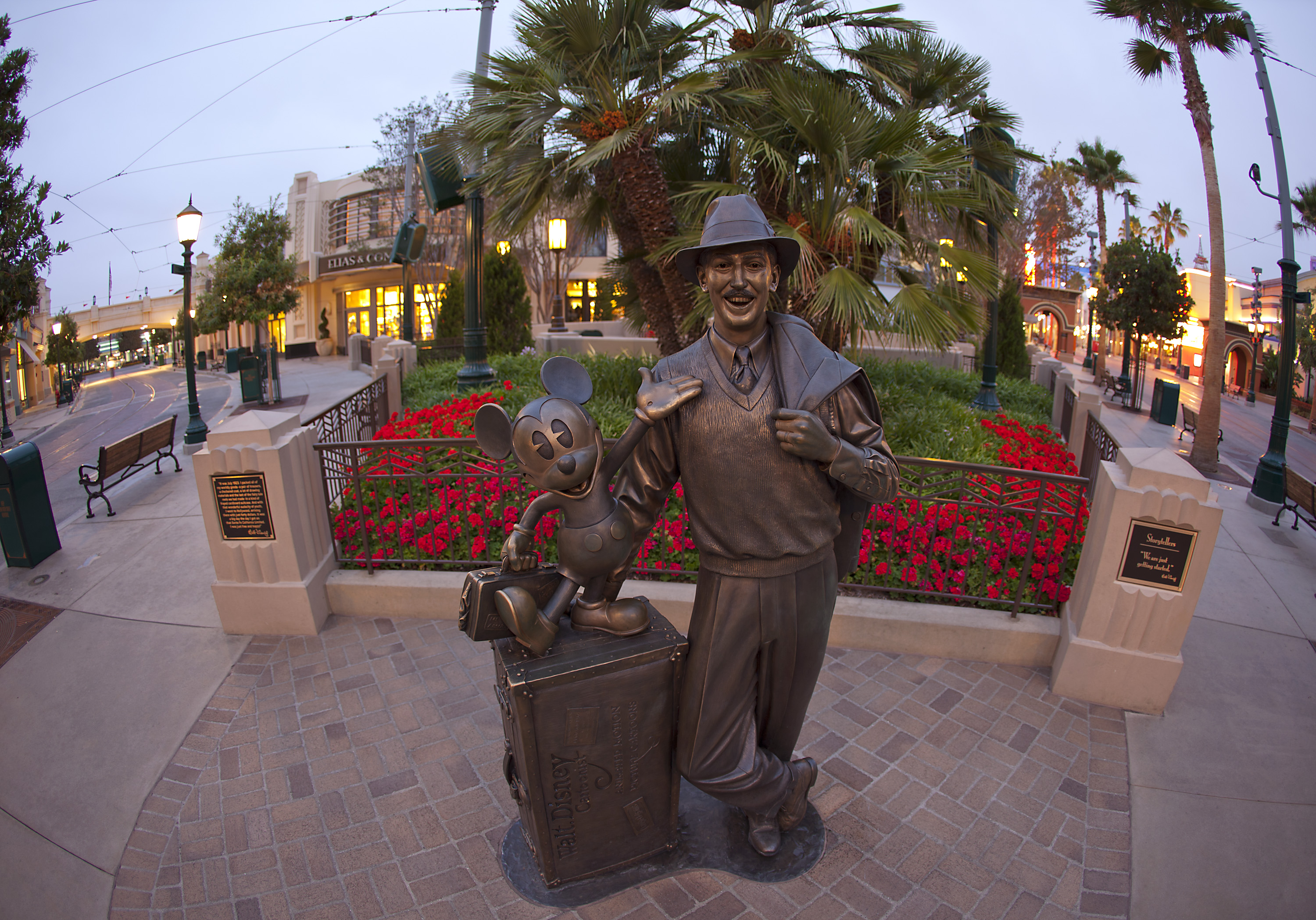 A bronze statue of Walt Disney and Mickey Mouse at Disneyland.