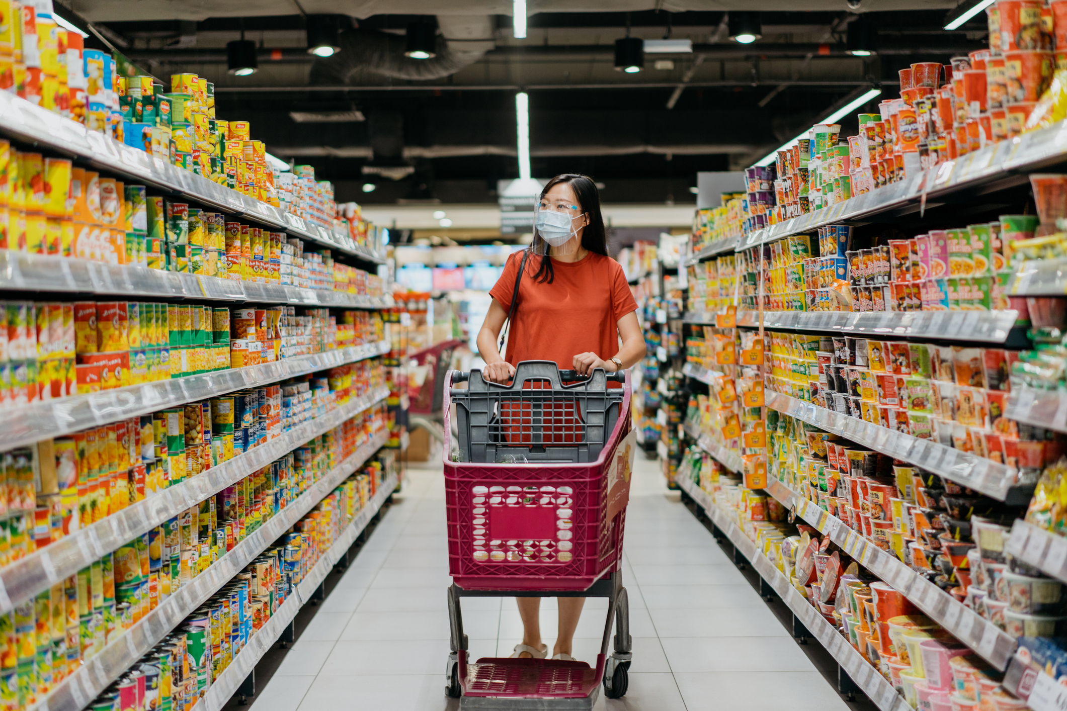 A person wearing a face mask shopping in a grocery store.