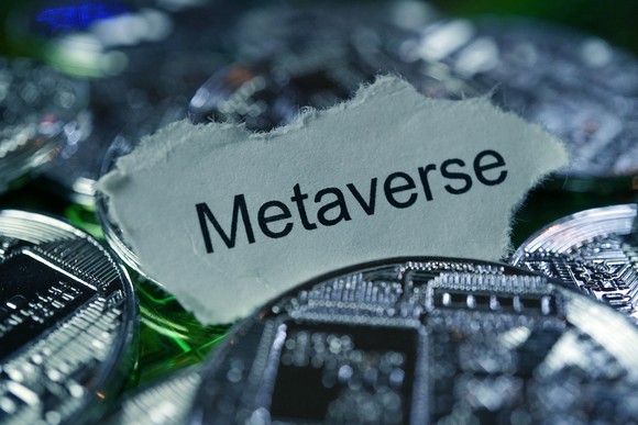 A piece of paper with "Metaverse" printed on it surrounded by silver coins.