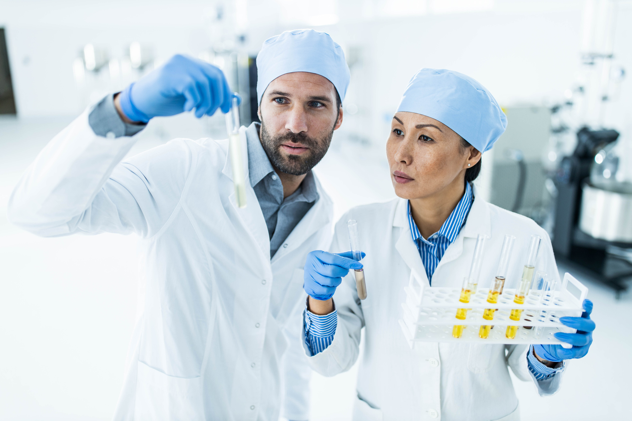 Two scientists reviewing a sample in a tube.