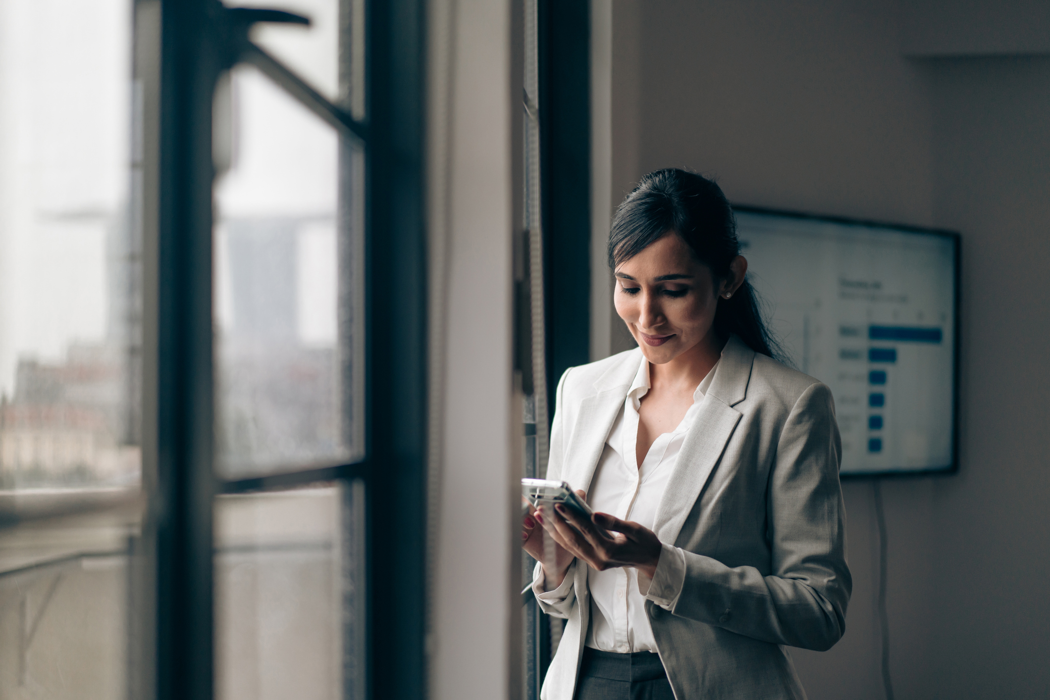 Businessperson using mobile phone in office.