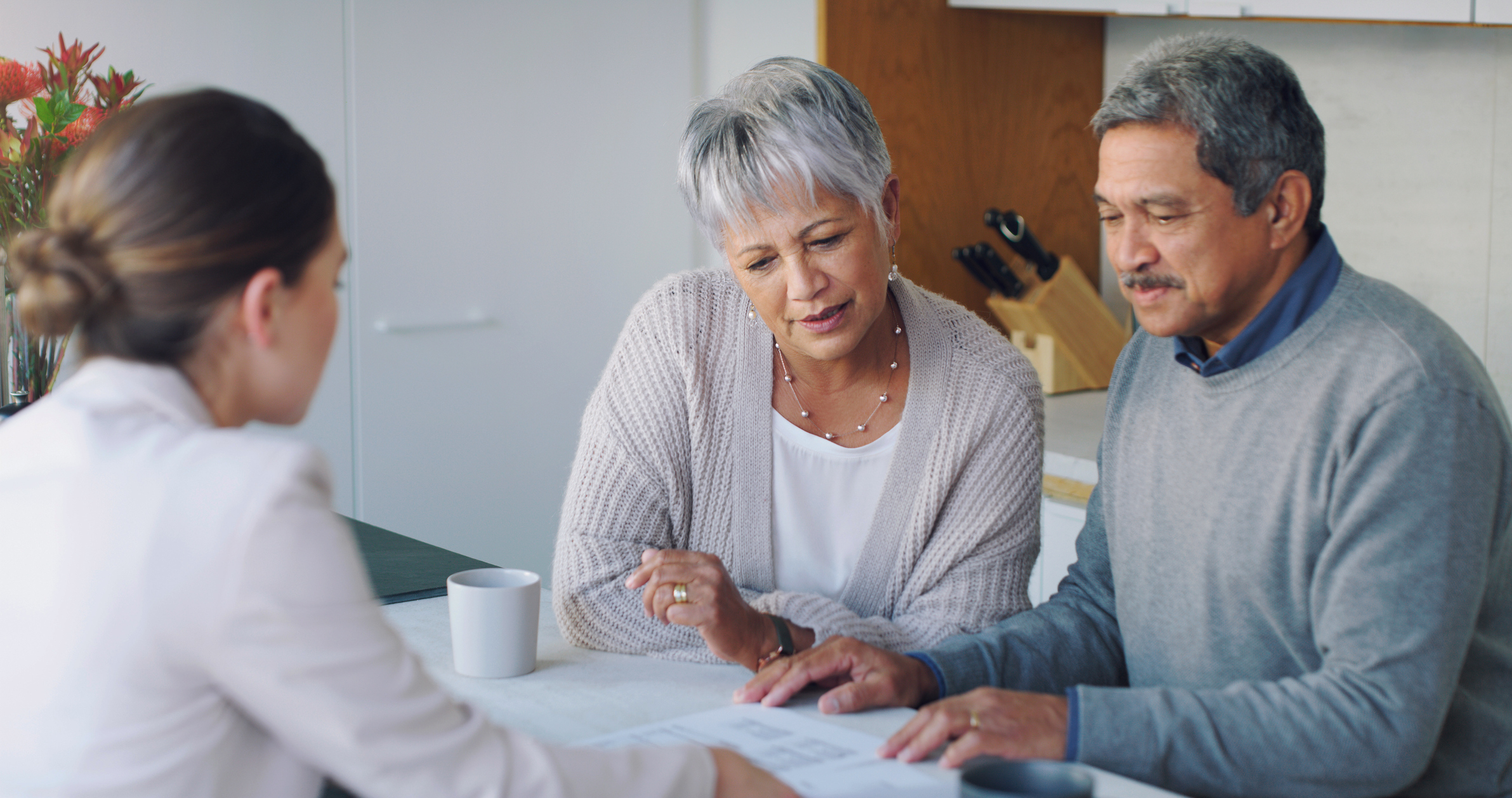 A couple reviews paperwork with an advisor.