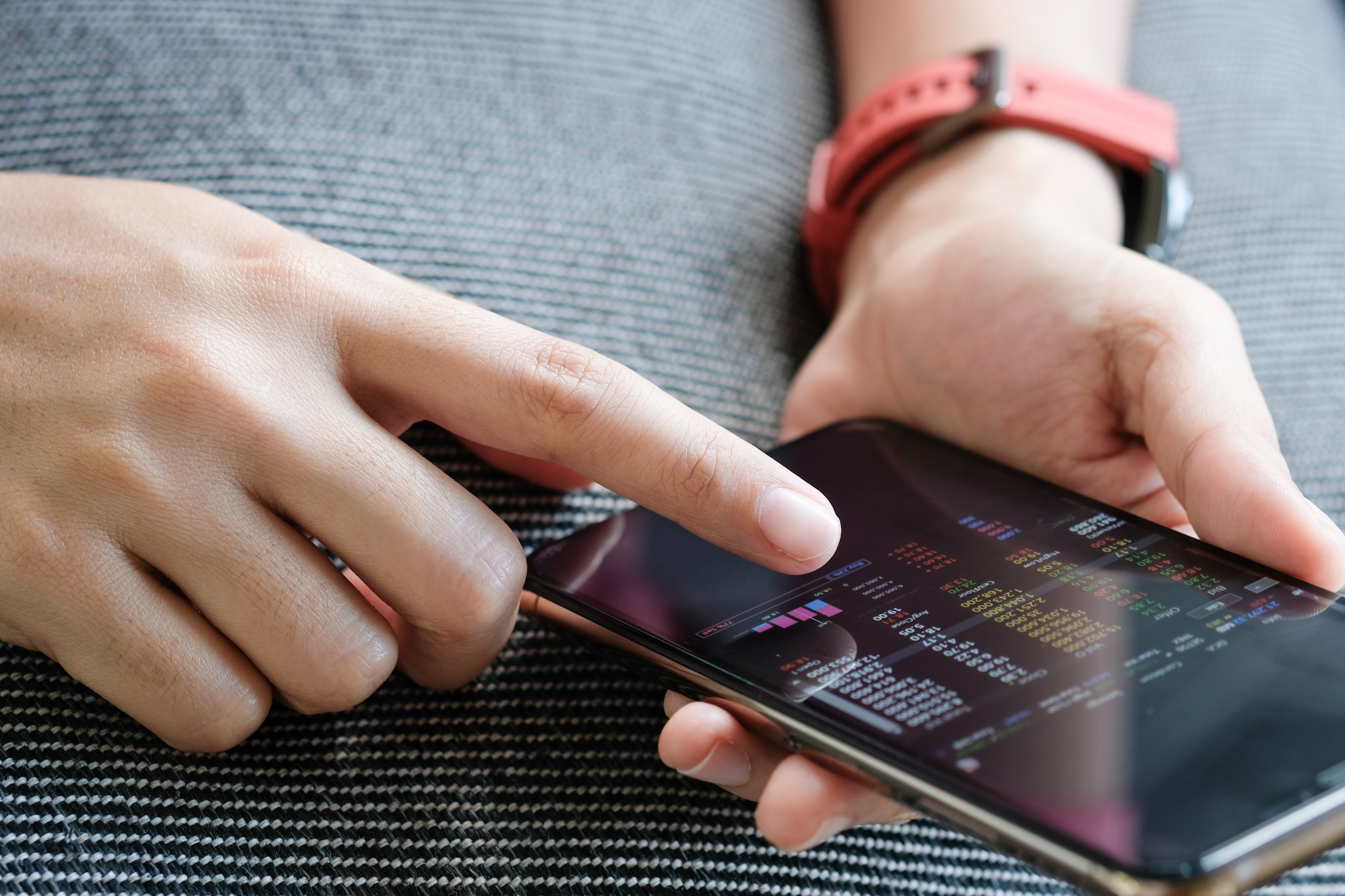 Someone using a smartphone to check stock prices.