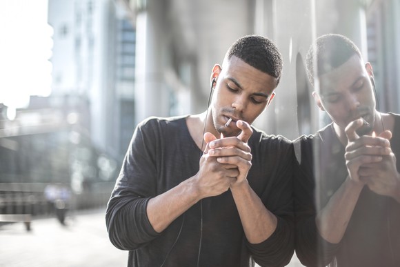 Man lighting up a cigarette.