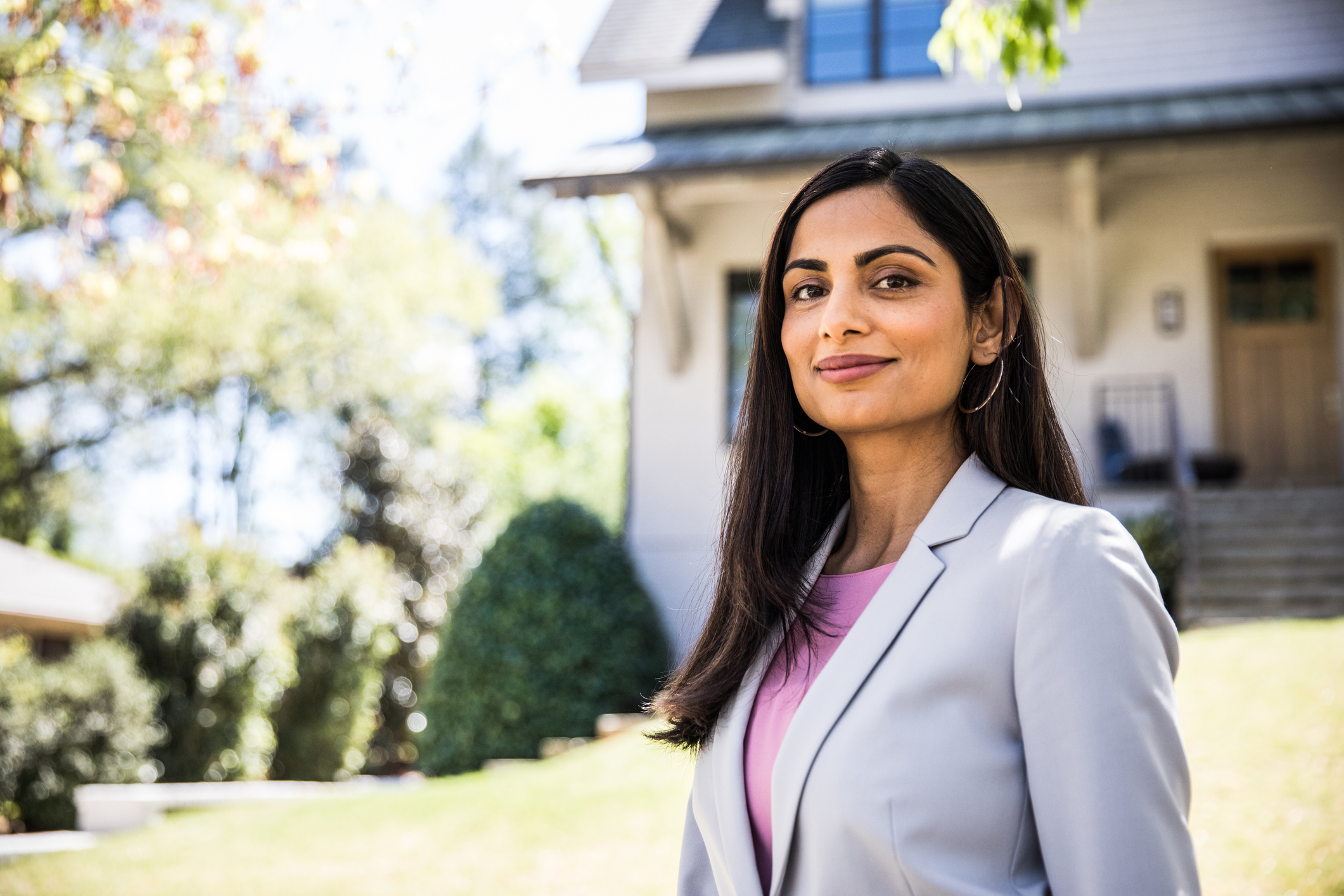 Real estate agent standing in the front yard of a house.