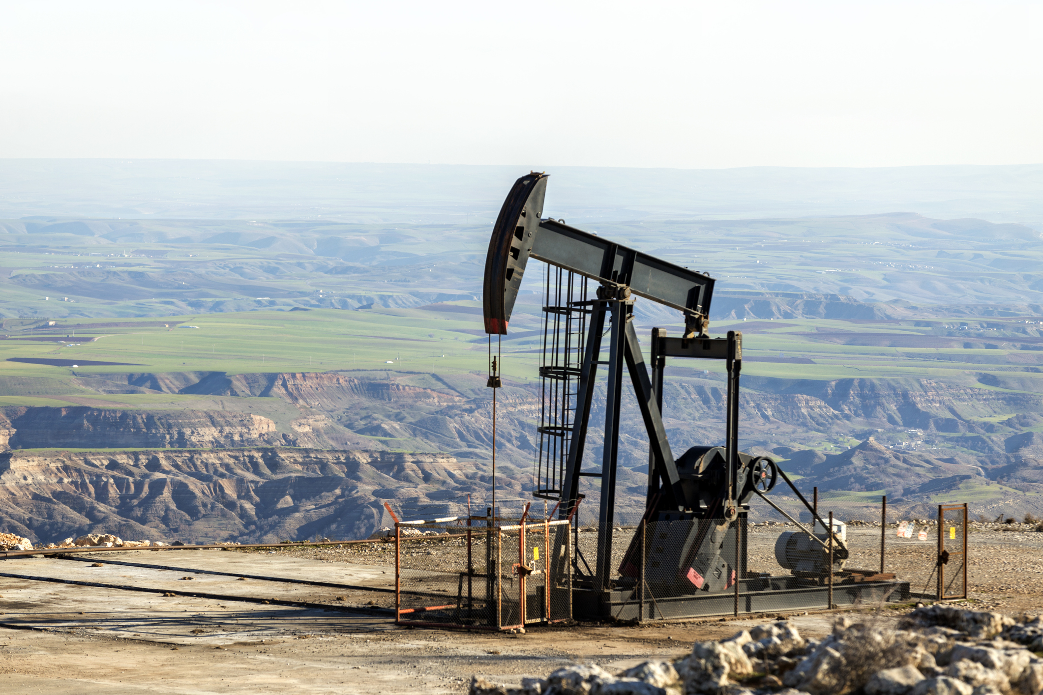 A pumpjack operating in a large oil field.
