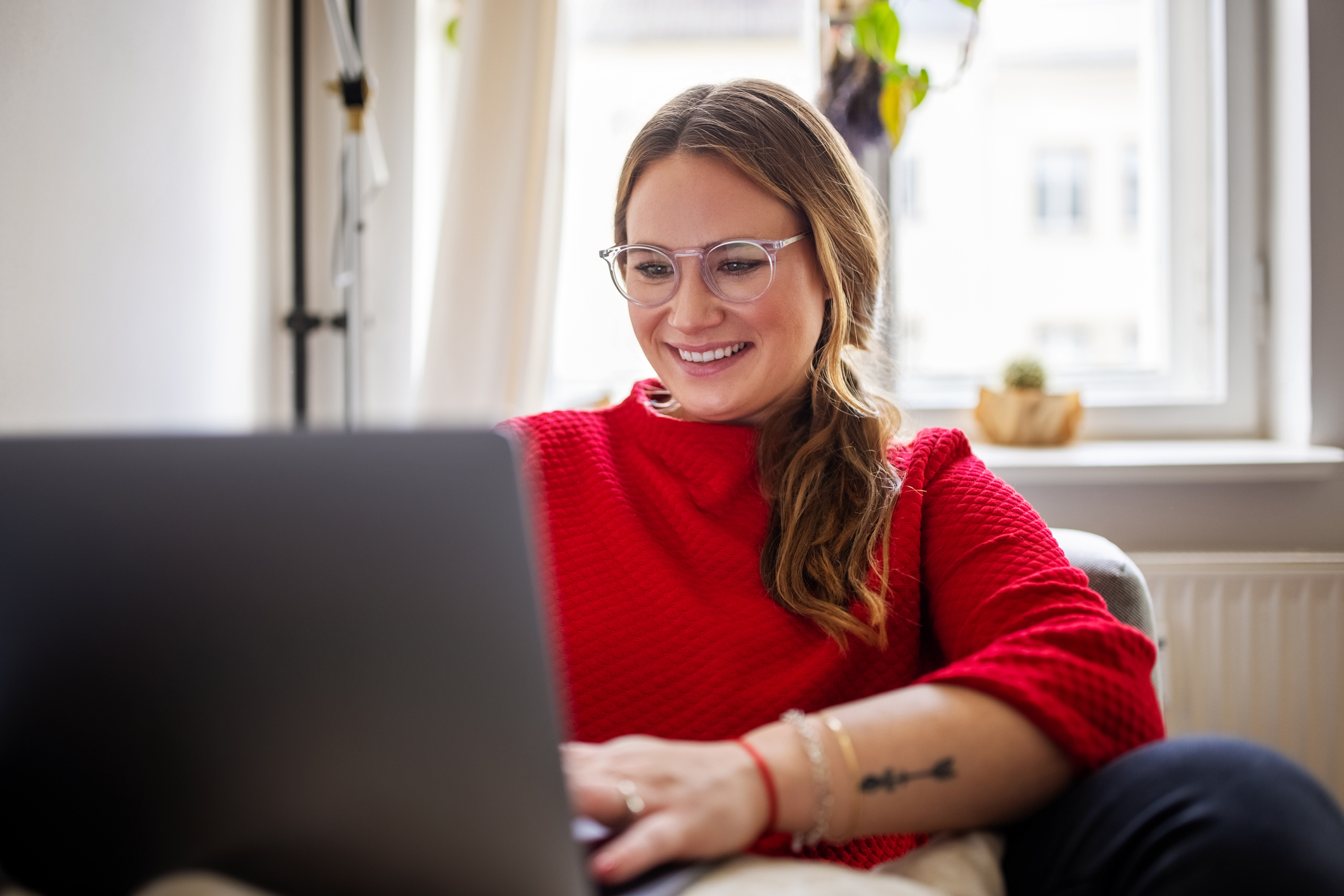 Woman using laptop and smiling.