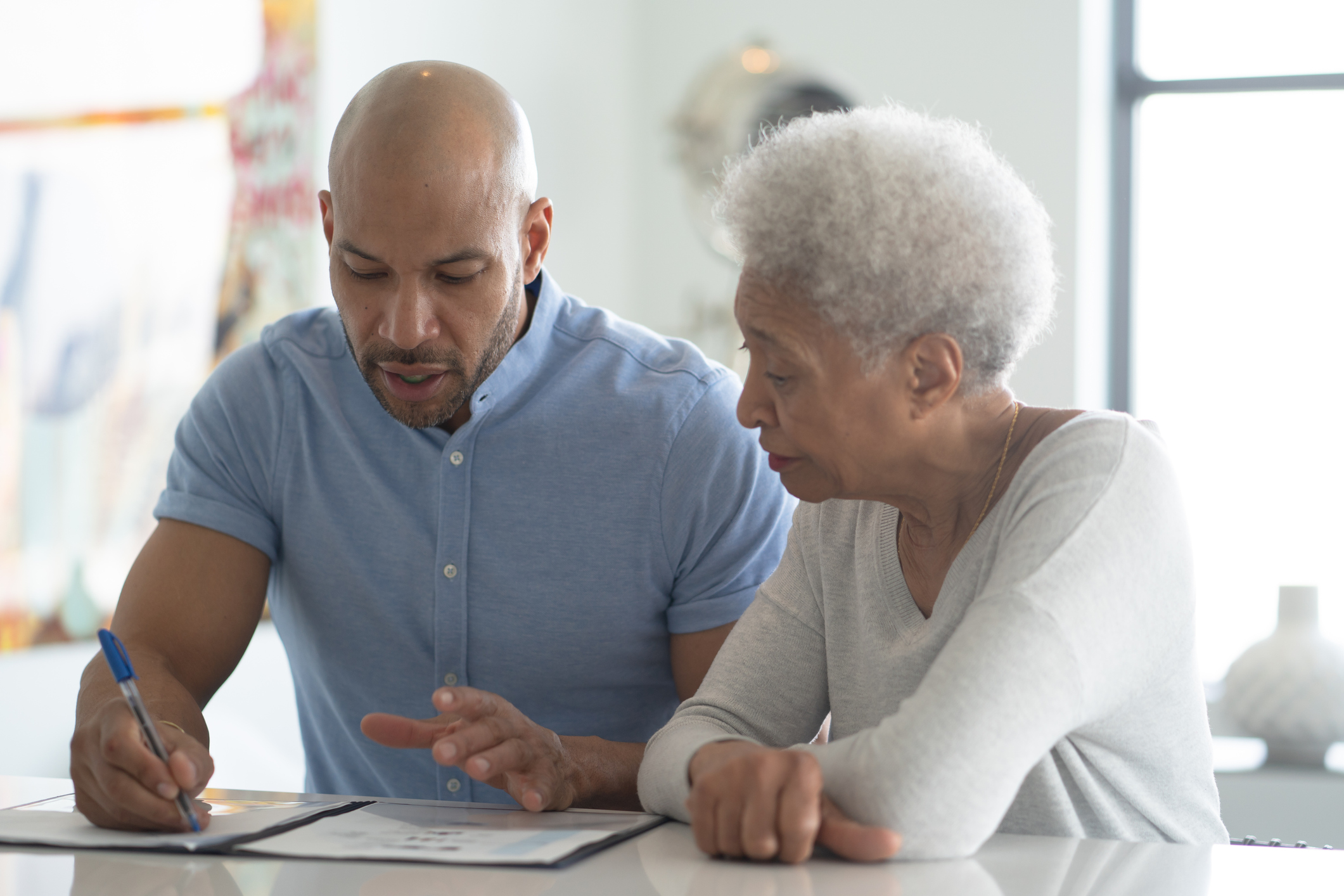 Two people sitting at a table looking at documents.