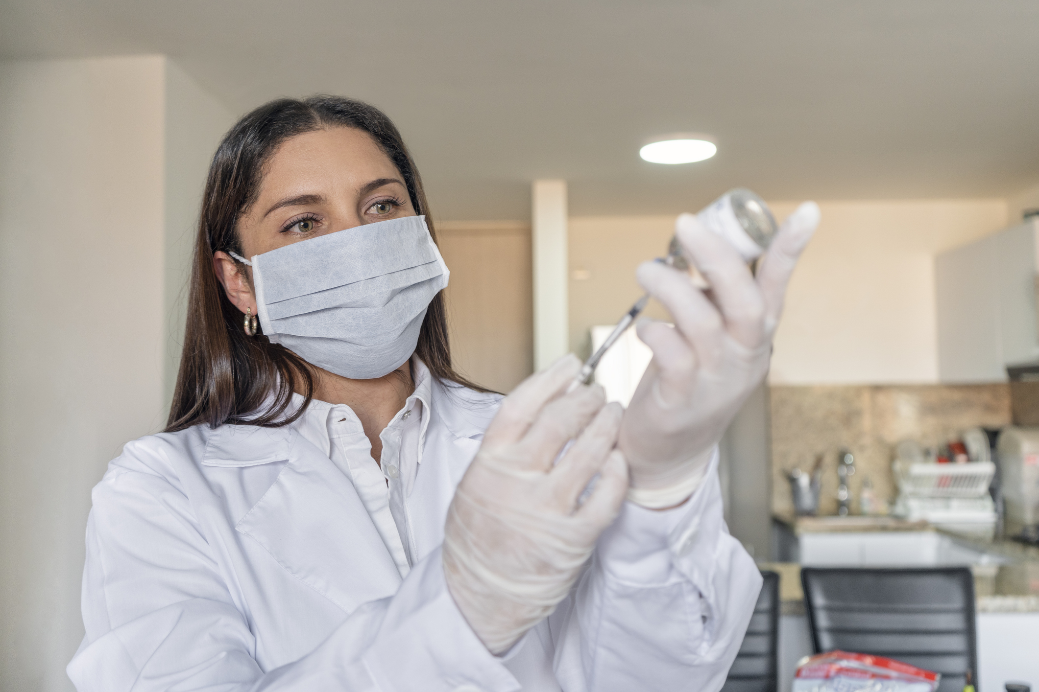 A healthcare worker loads a syringe with a dose of coronavirus vaccine.
