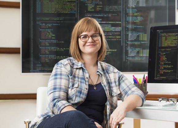 Someone in front of a computer screen displaying code.