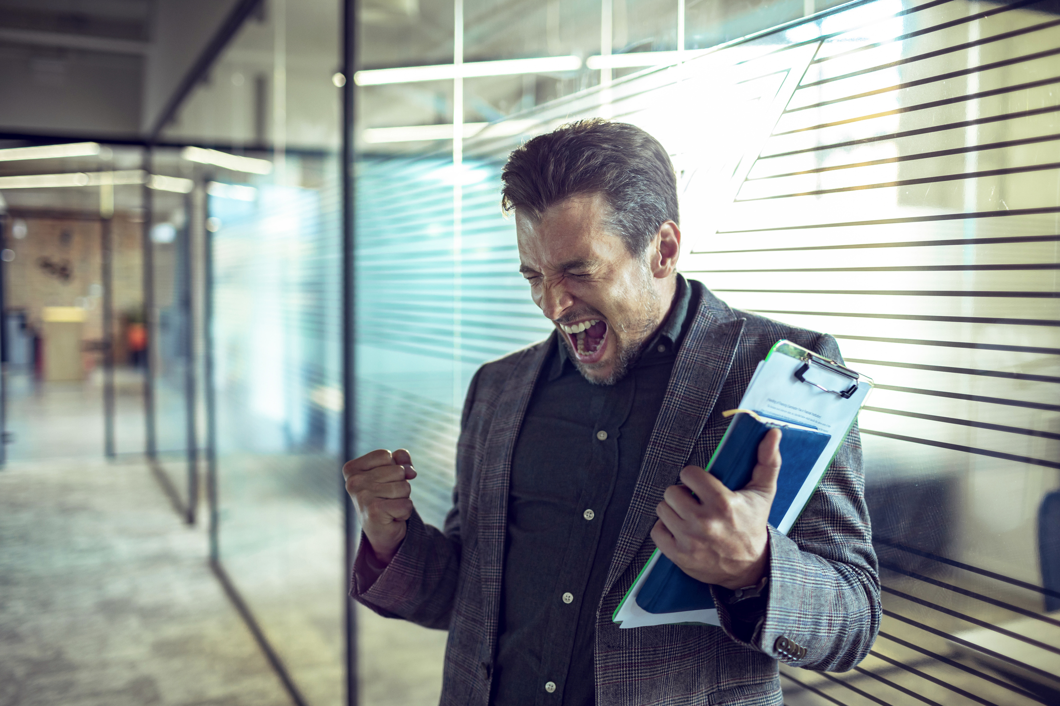 Person holding a book and a clipboard, cheering.