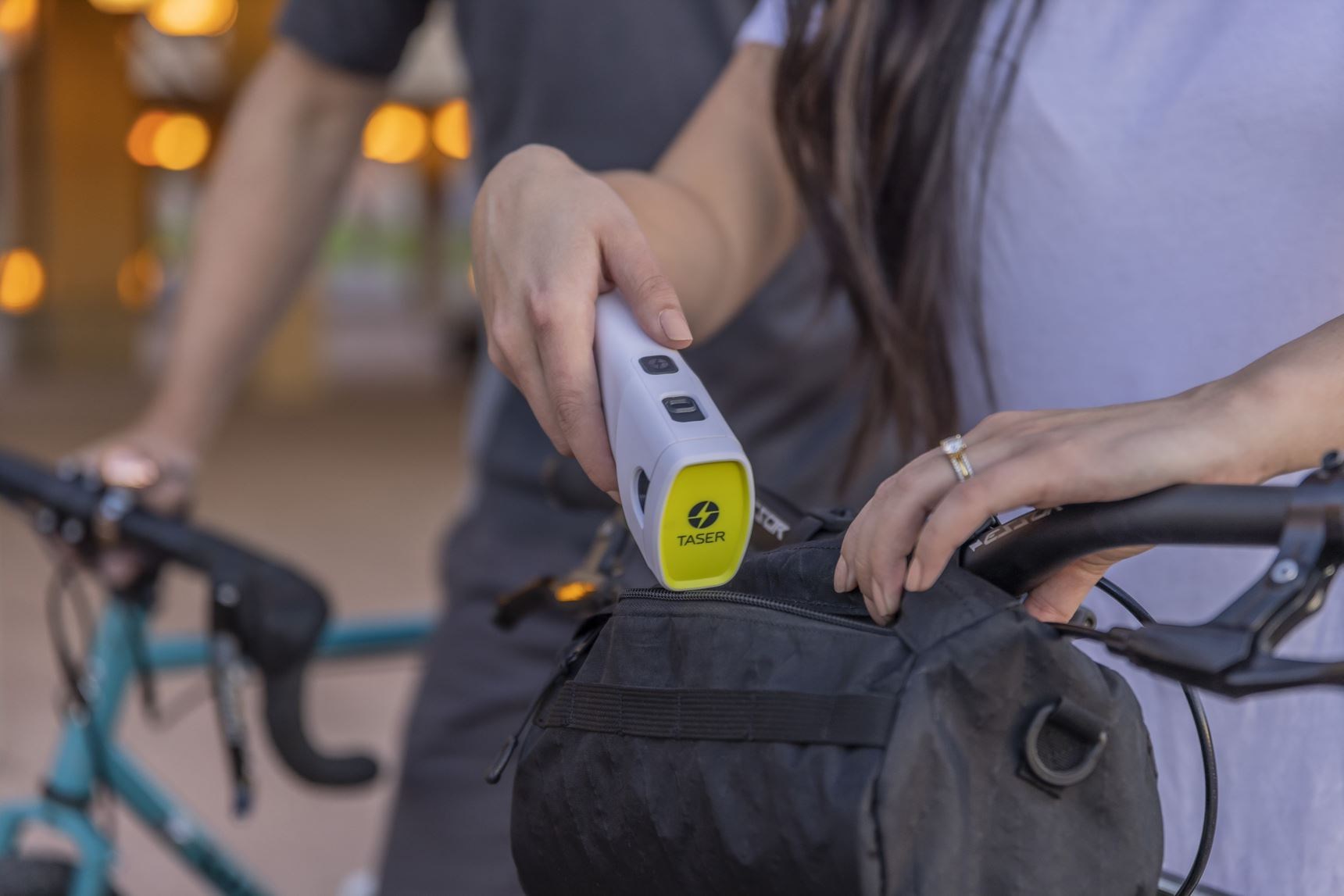 Person putting a Taser Bolt 2 in a bag.