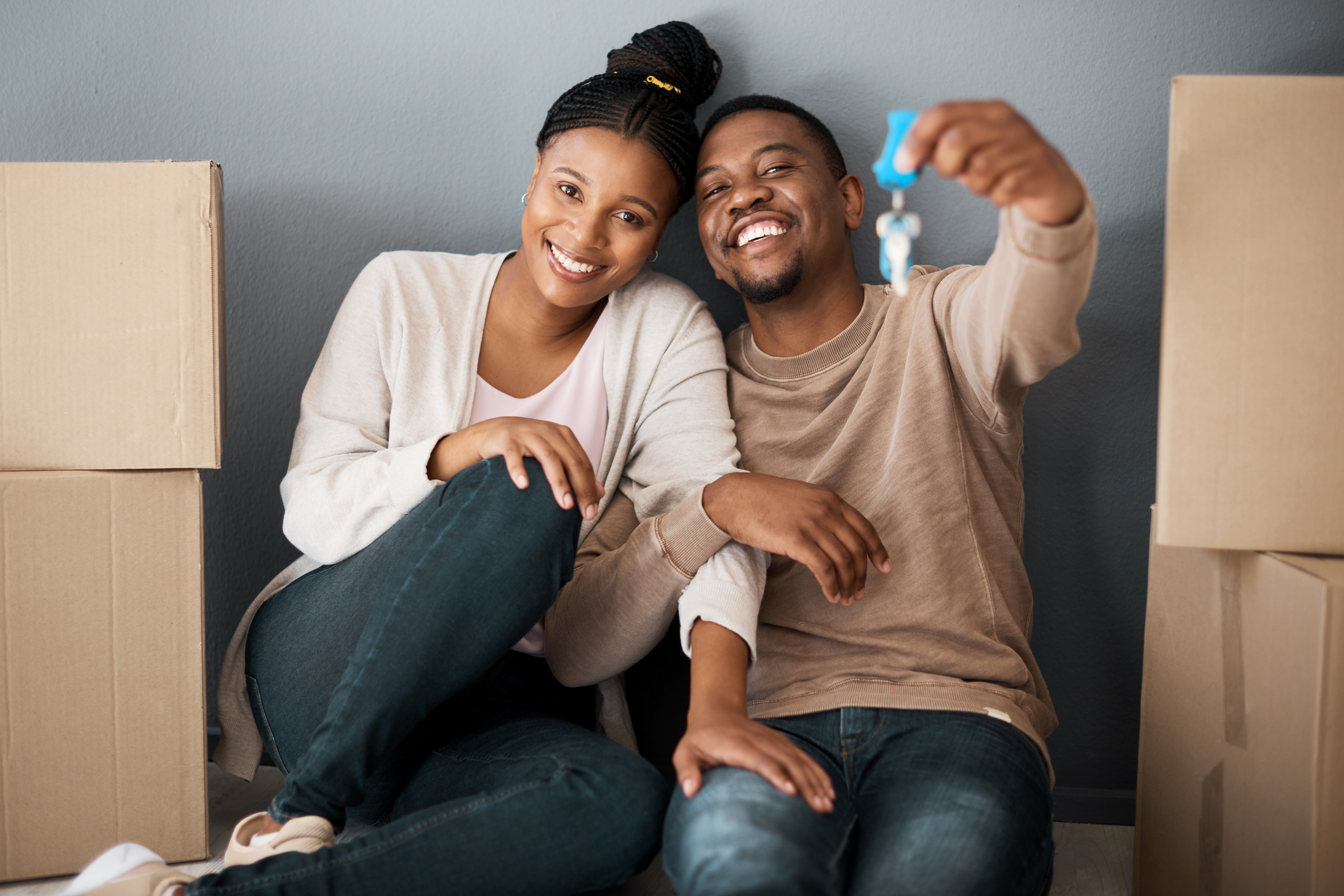 Young couple holding keys to their new home.