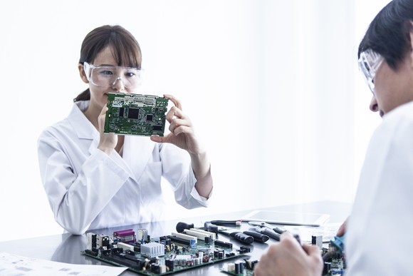 Two people examining a chipset.