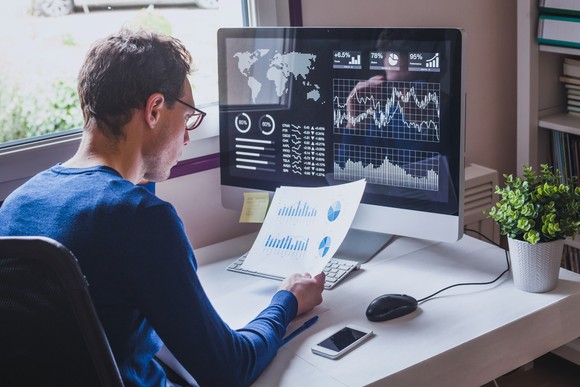 An investor reviews a computer screen with different metrics.