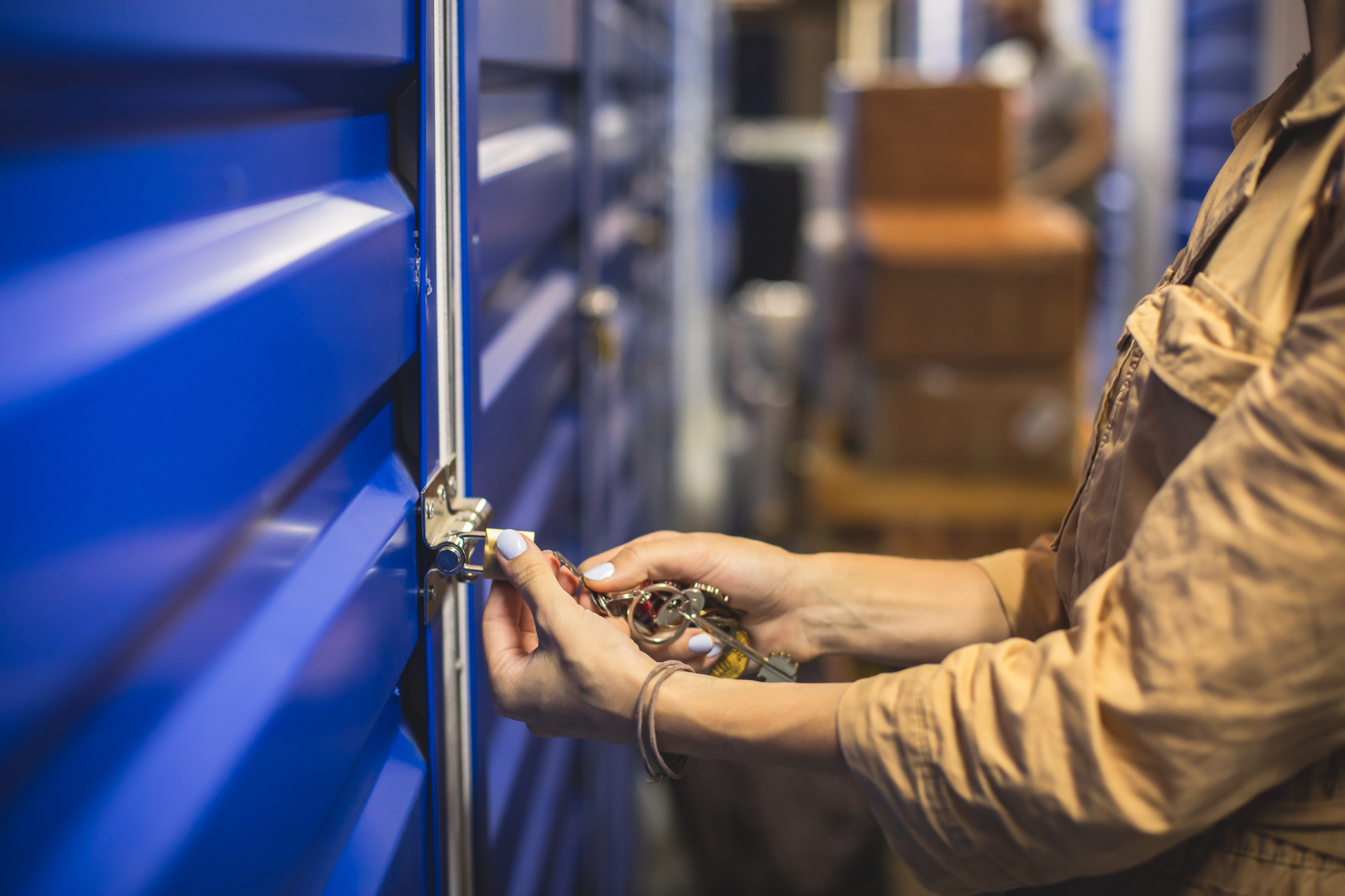 Person locking self- storage unit in self- storage facility.