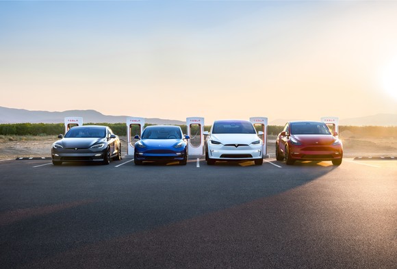 family of Tesla vehicles parked in front of superchargers.