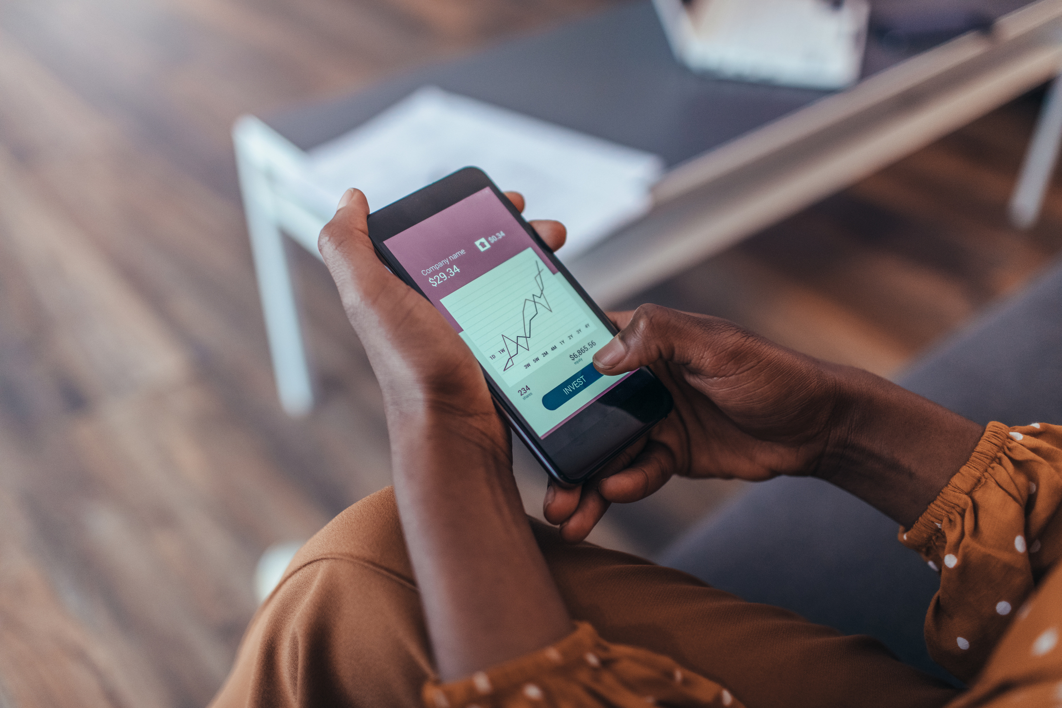 A person looking at a stock chart on a smartphone.