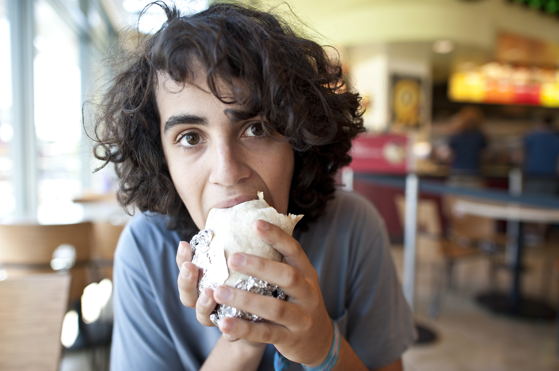 Person eating a fresh burrito.
