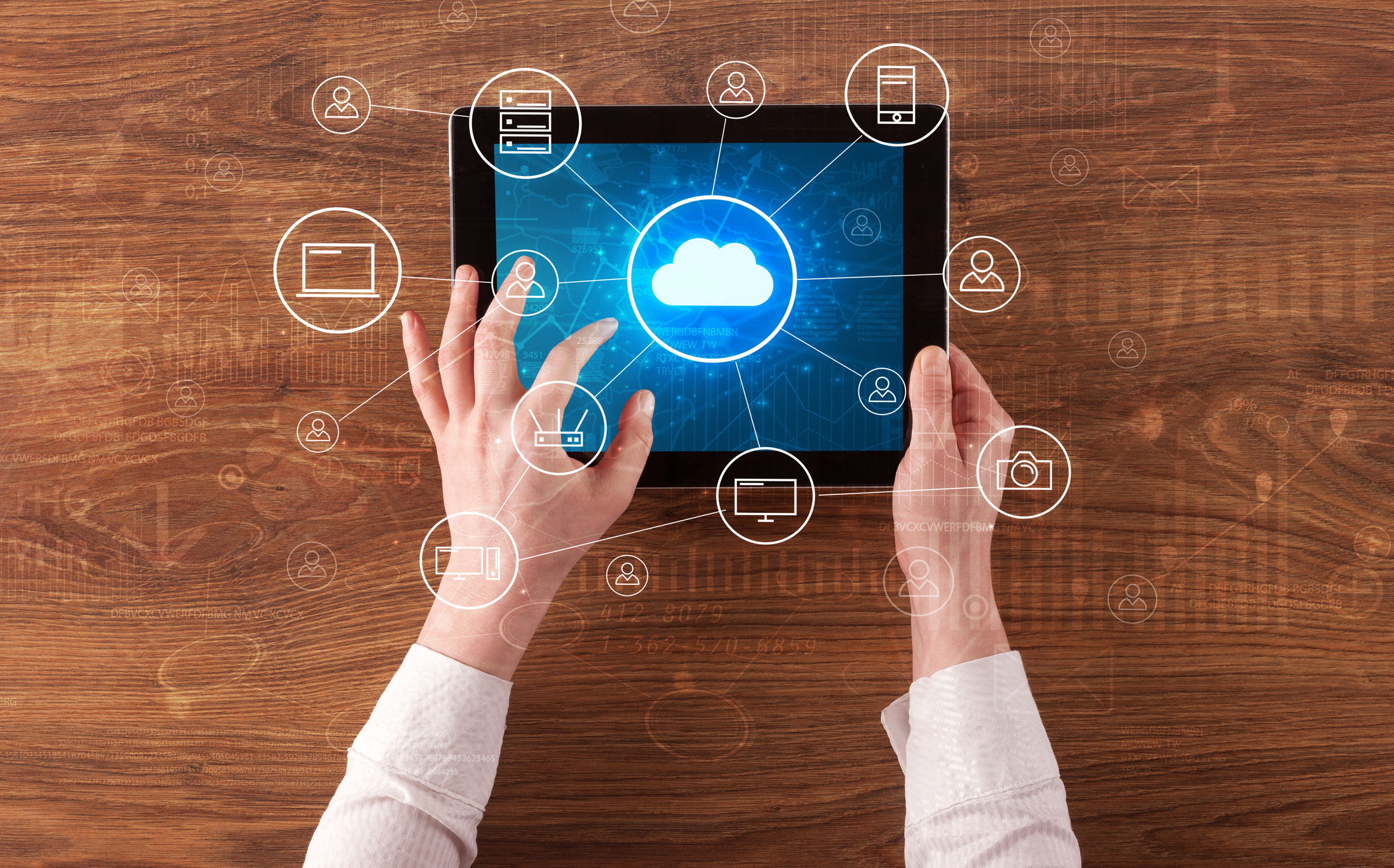 Two hands work on a tablet with a cloud icon on it.