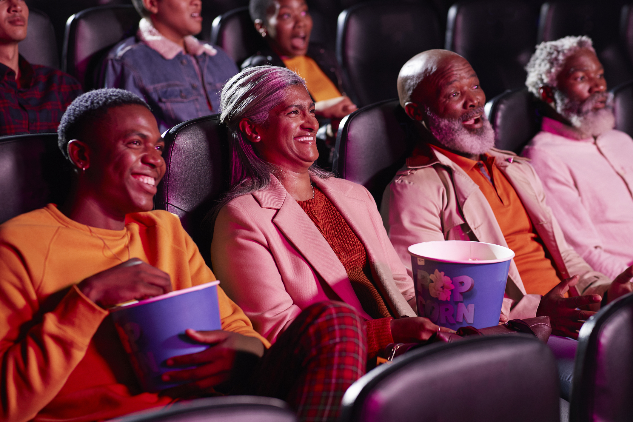 A group of people watching something in a movie theater.