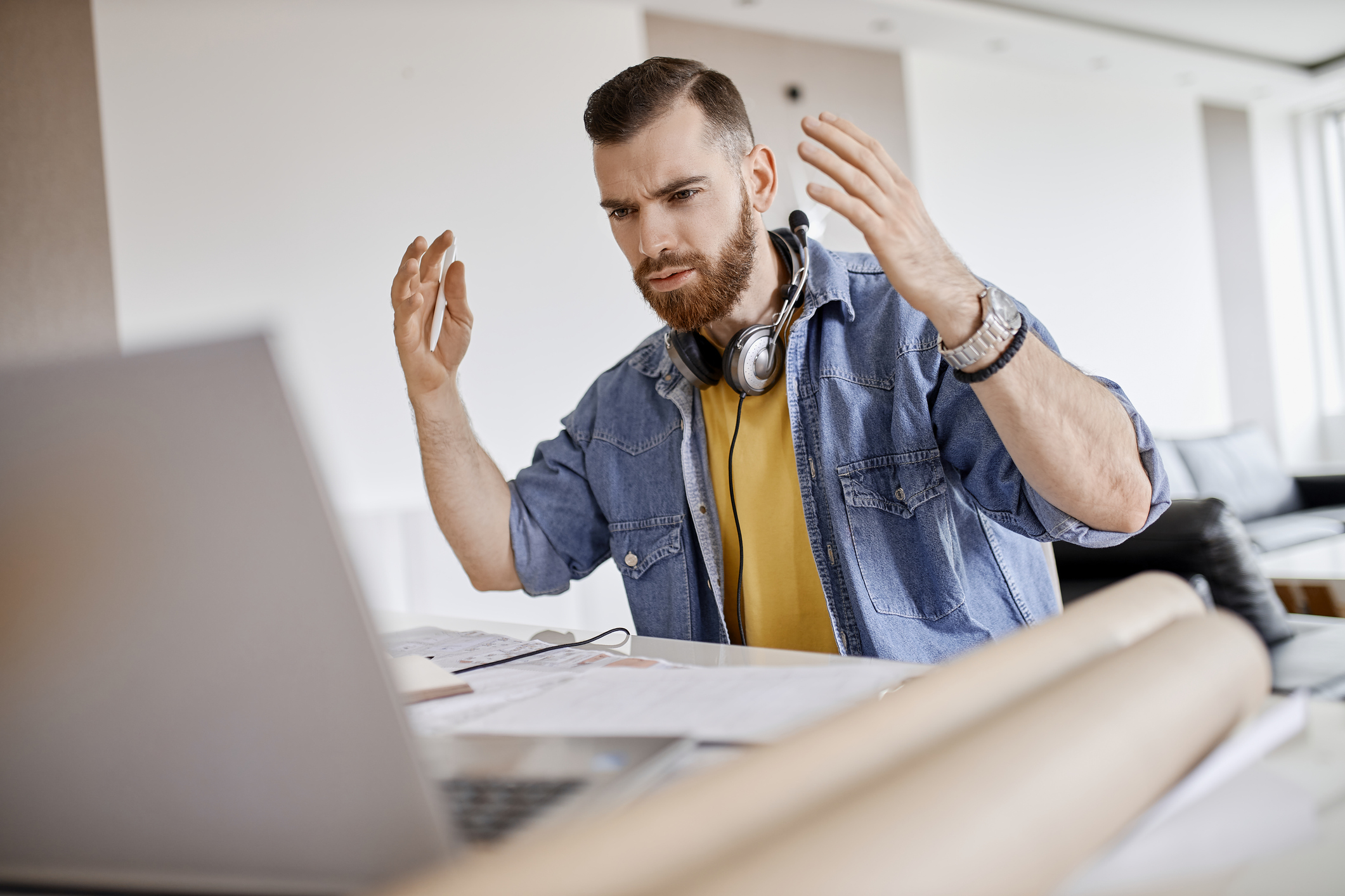 Young man at home is upset at something on his laptop.