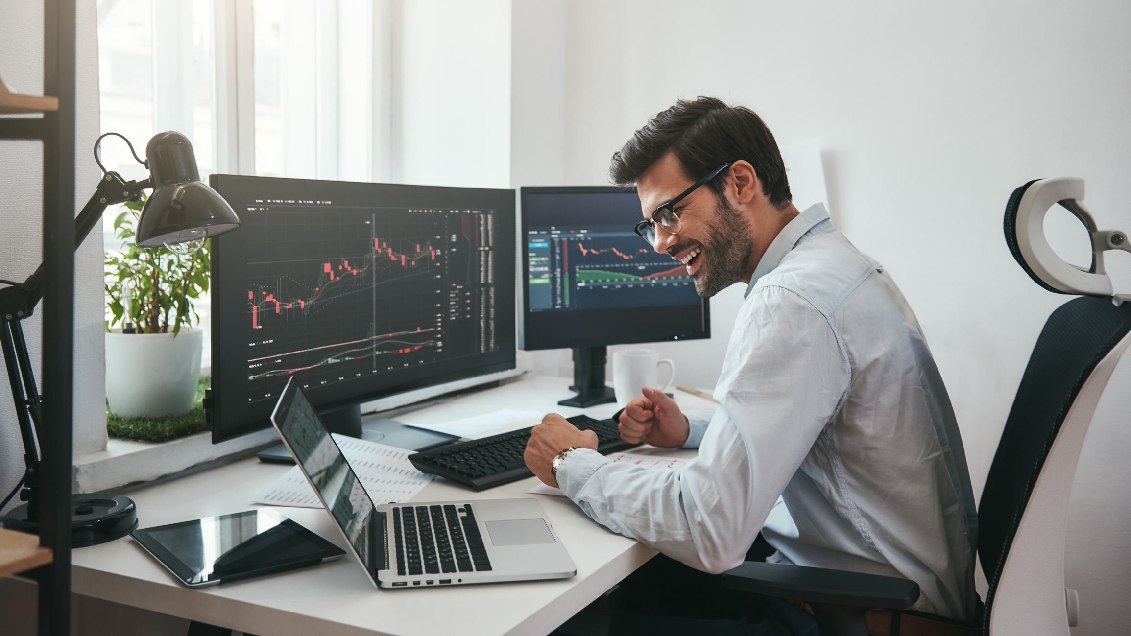 Young man working at a computer checking stocks