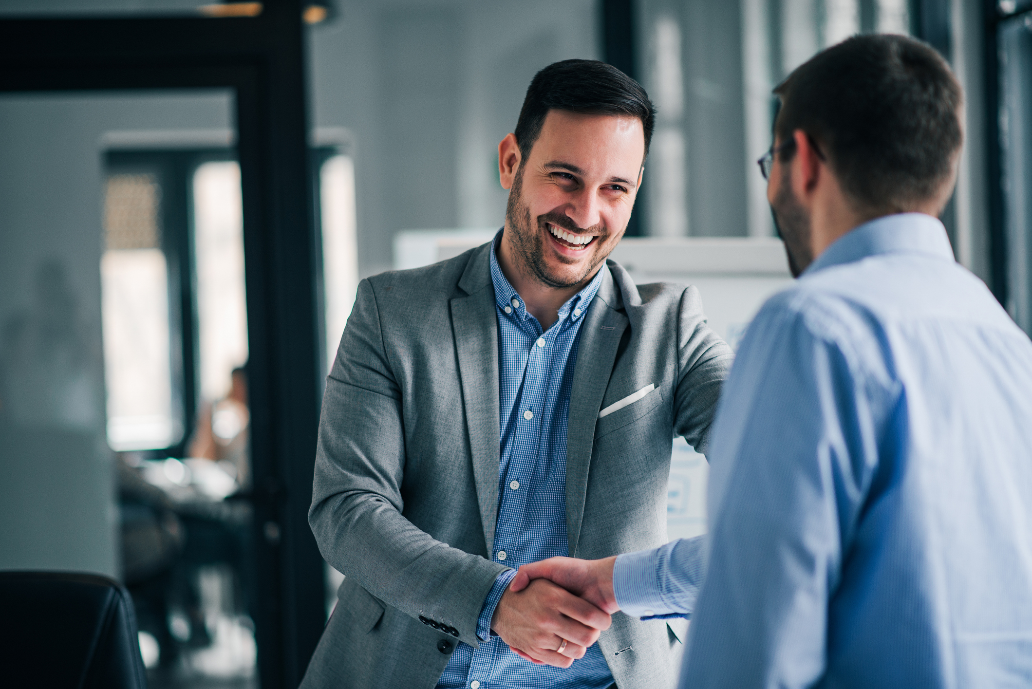 Two people in suits shaking hands.