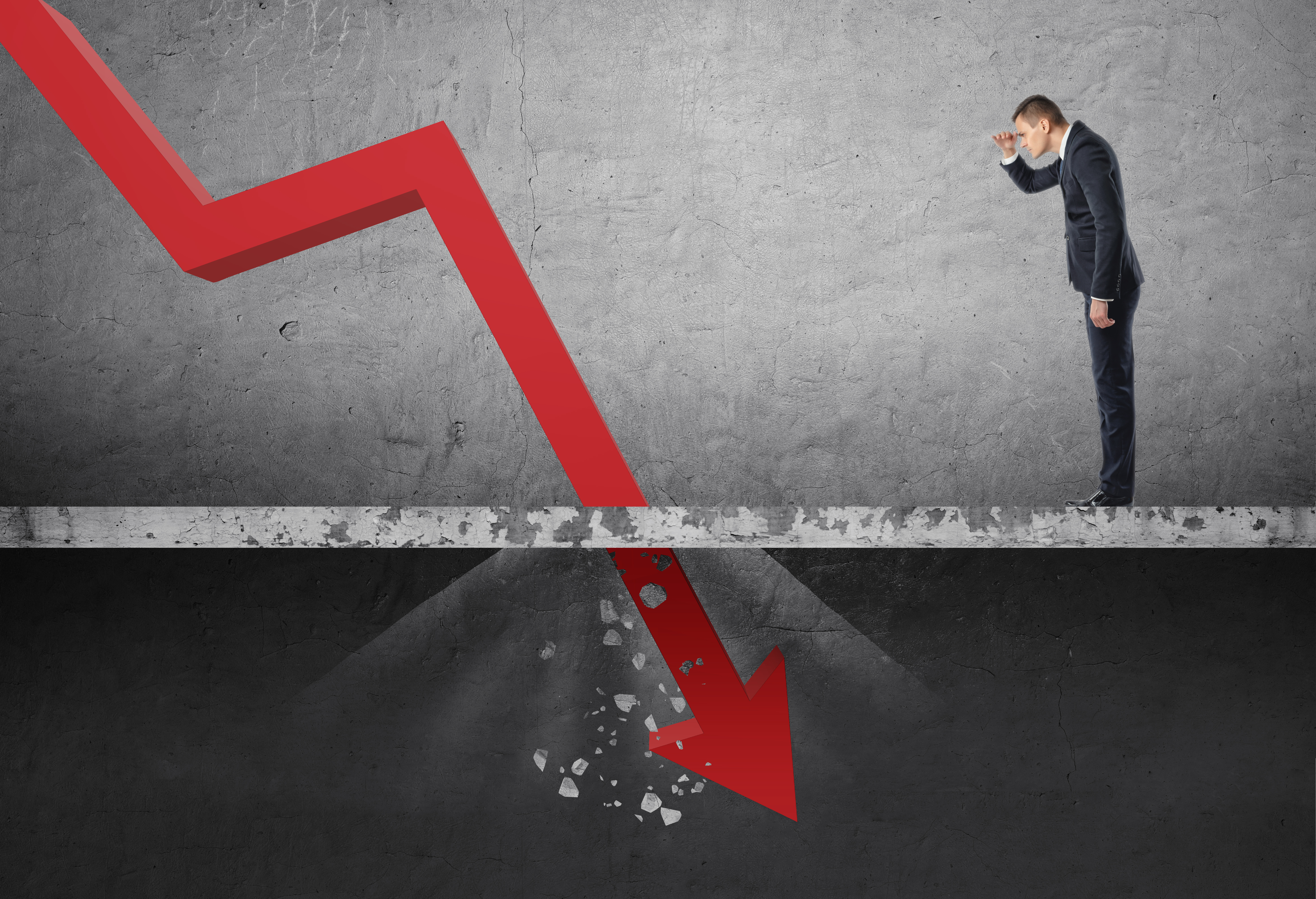 Investor watching a red arrow crash through the floor.