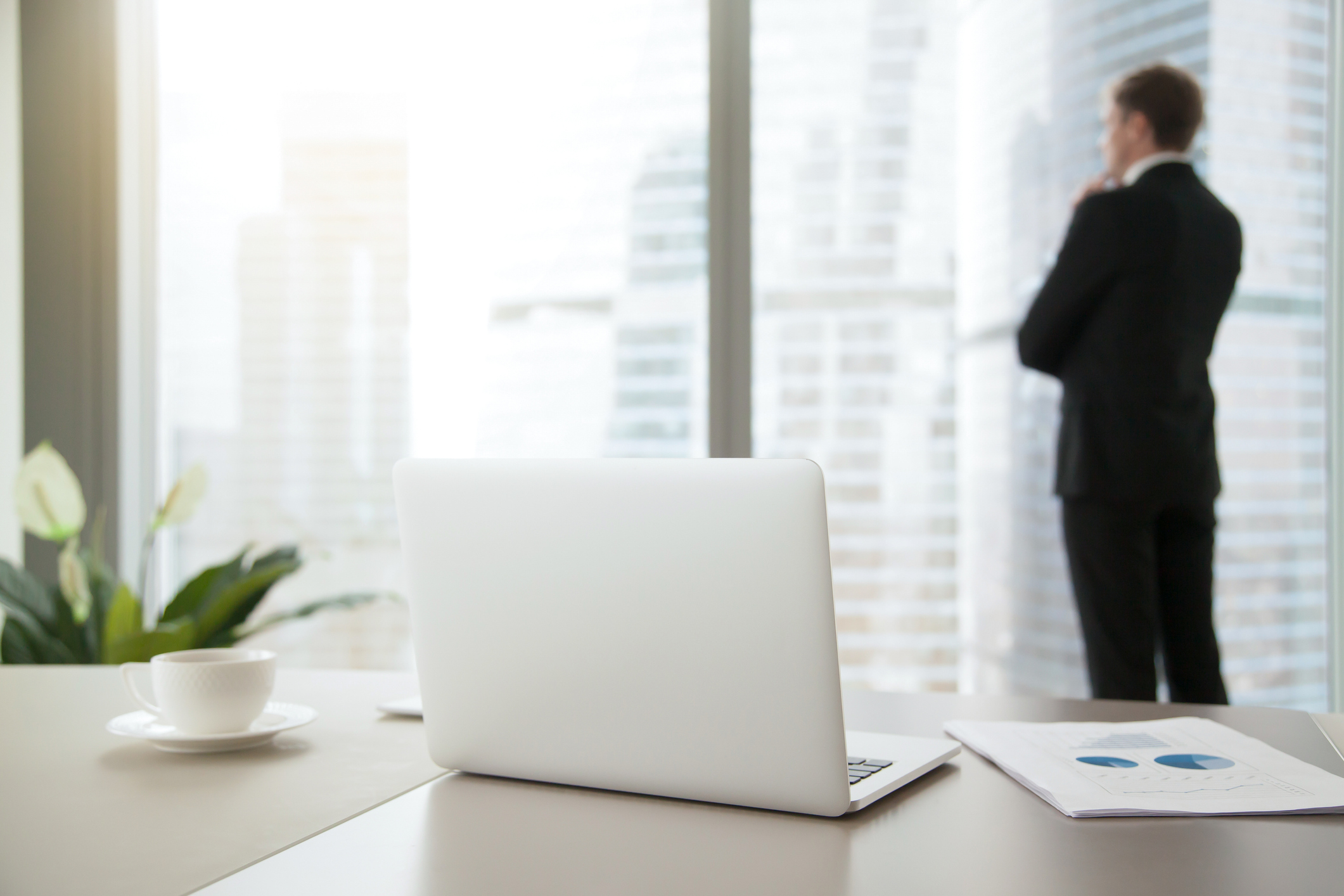 business person looking out window of office.