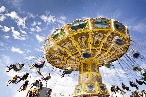 People on a ride are suspended in the air as they are spun around.  


