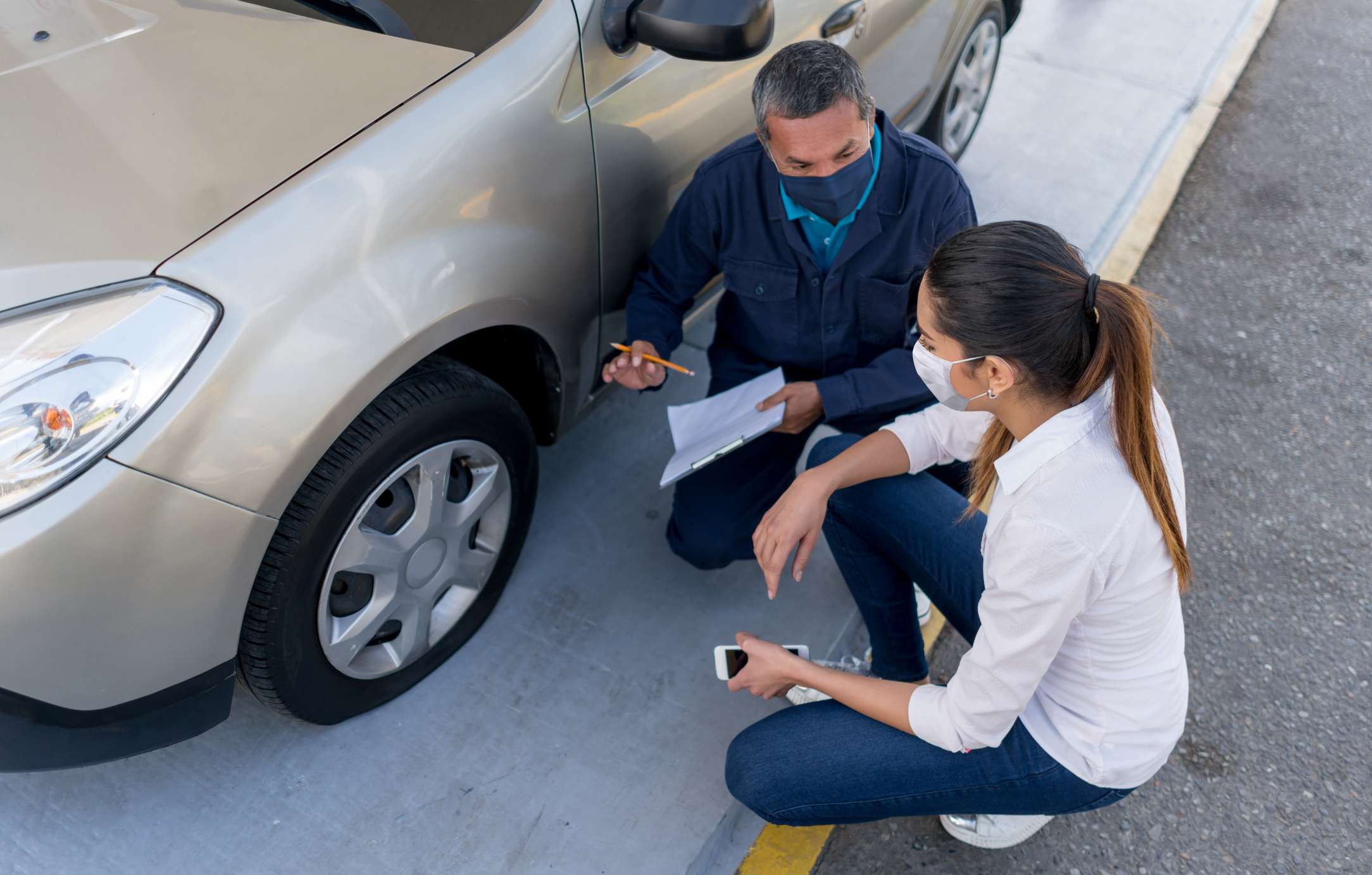 A mechanic reviews auto damage with a customer.