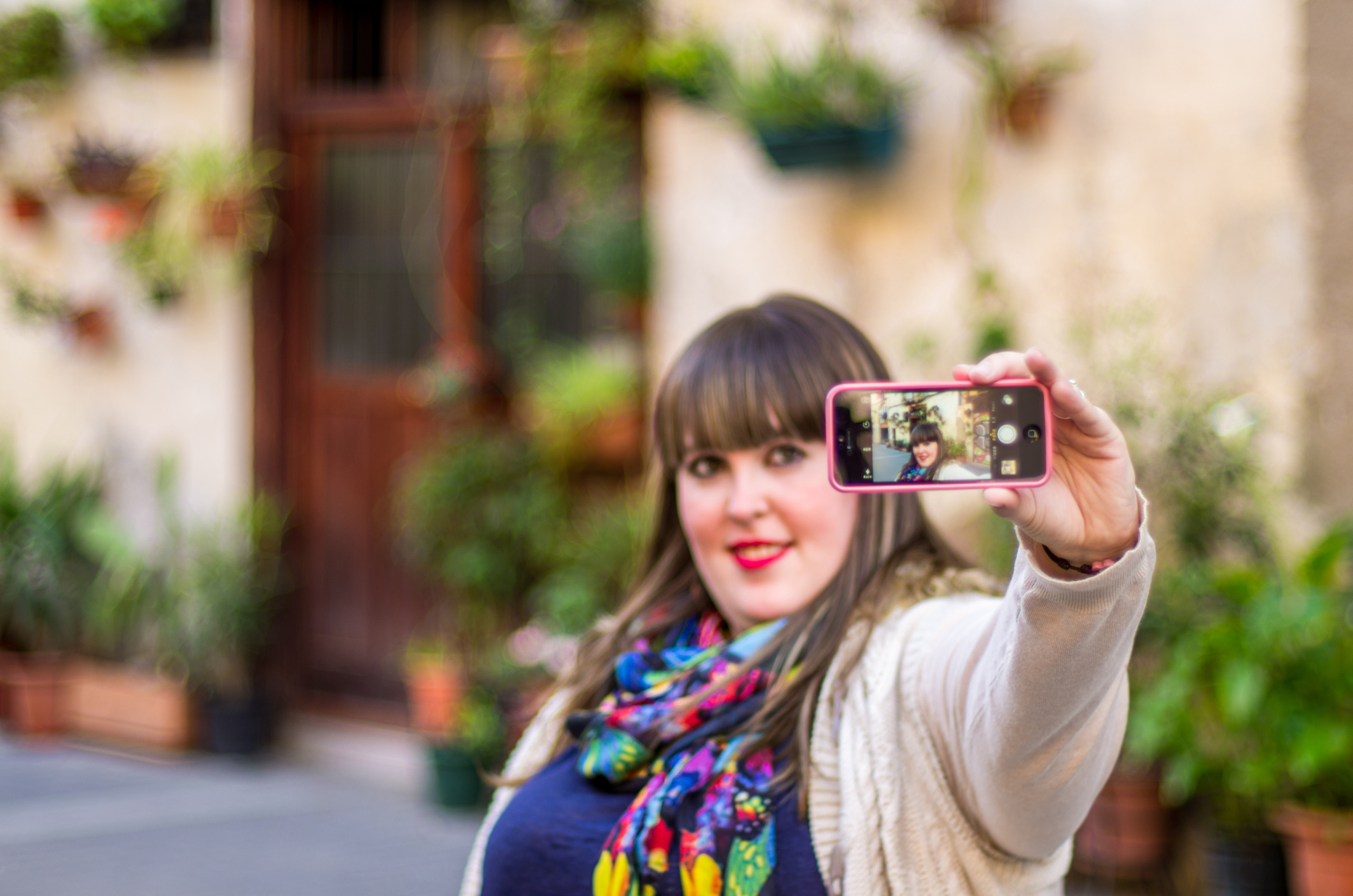 Person taking selfie with smartphone.