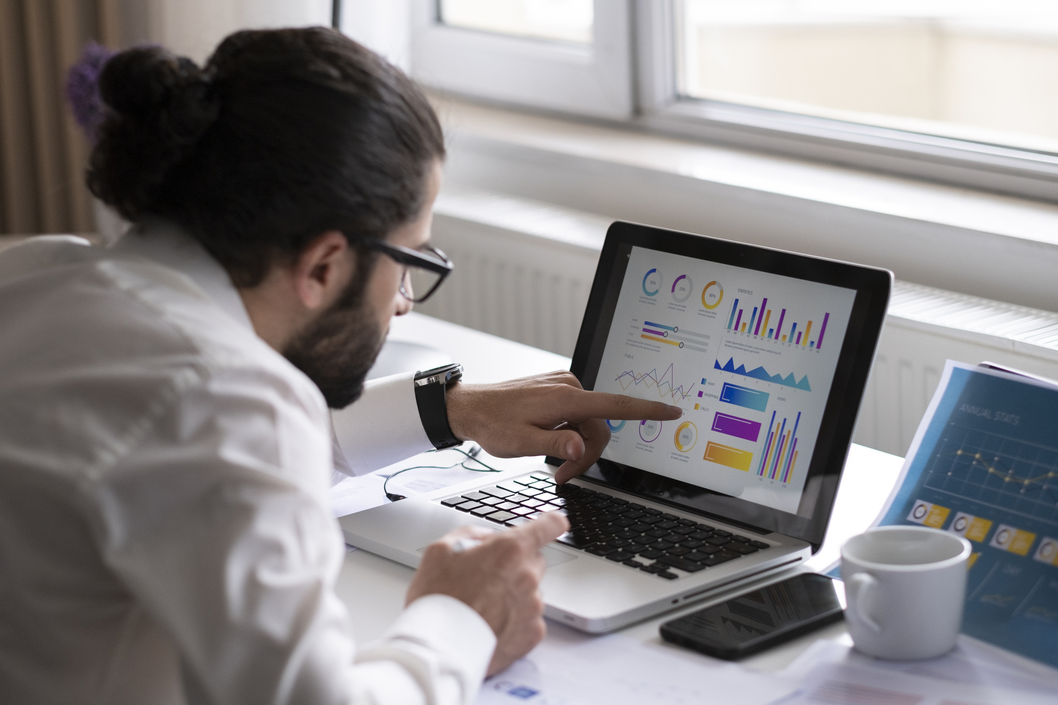 A person looking at graphs on a computer.