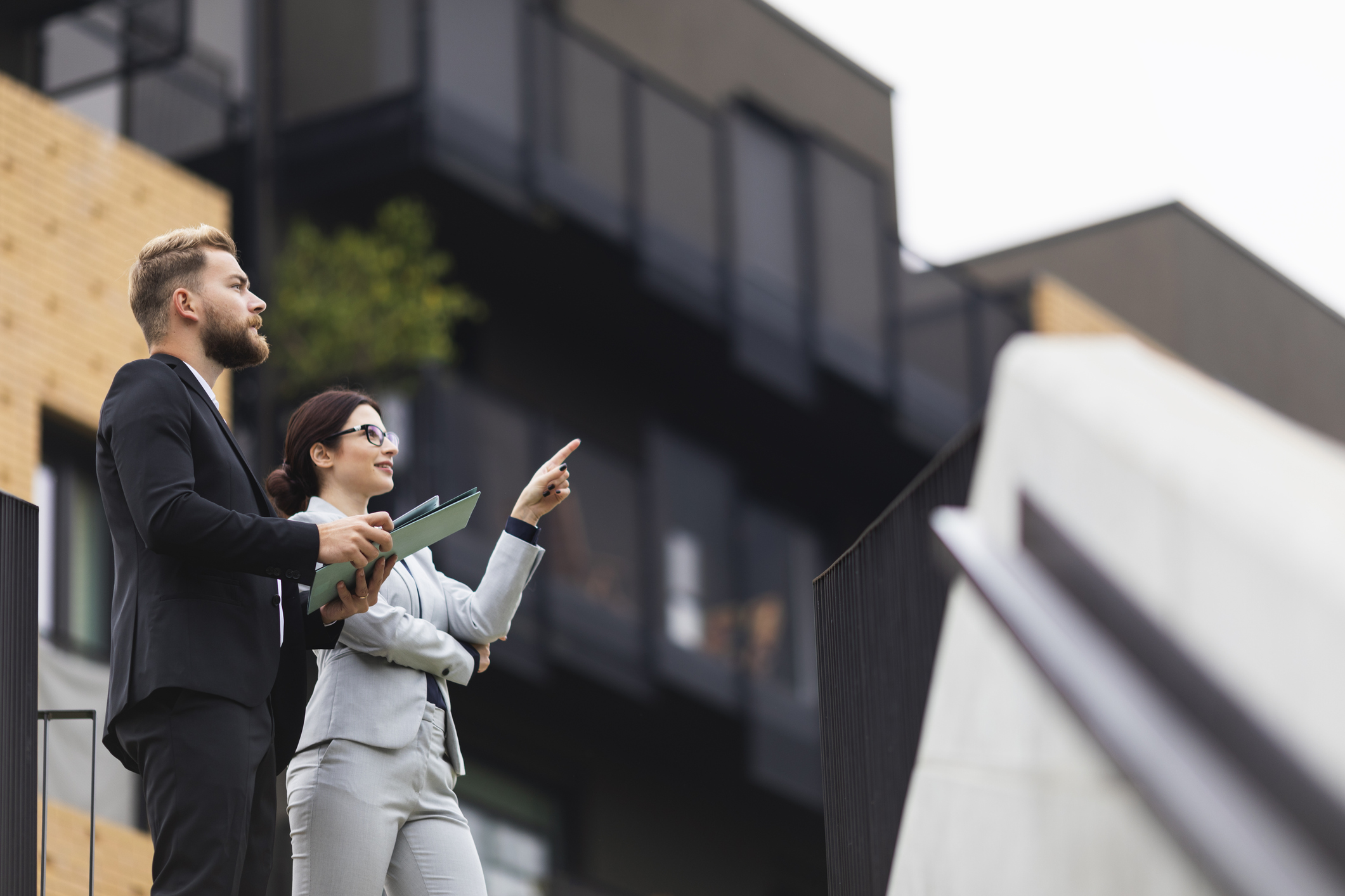 Two professionals are outside reviewing a property.