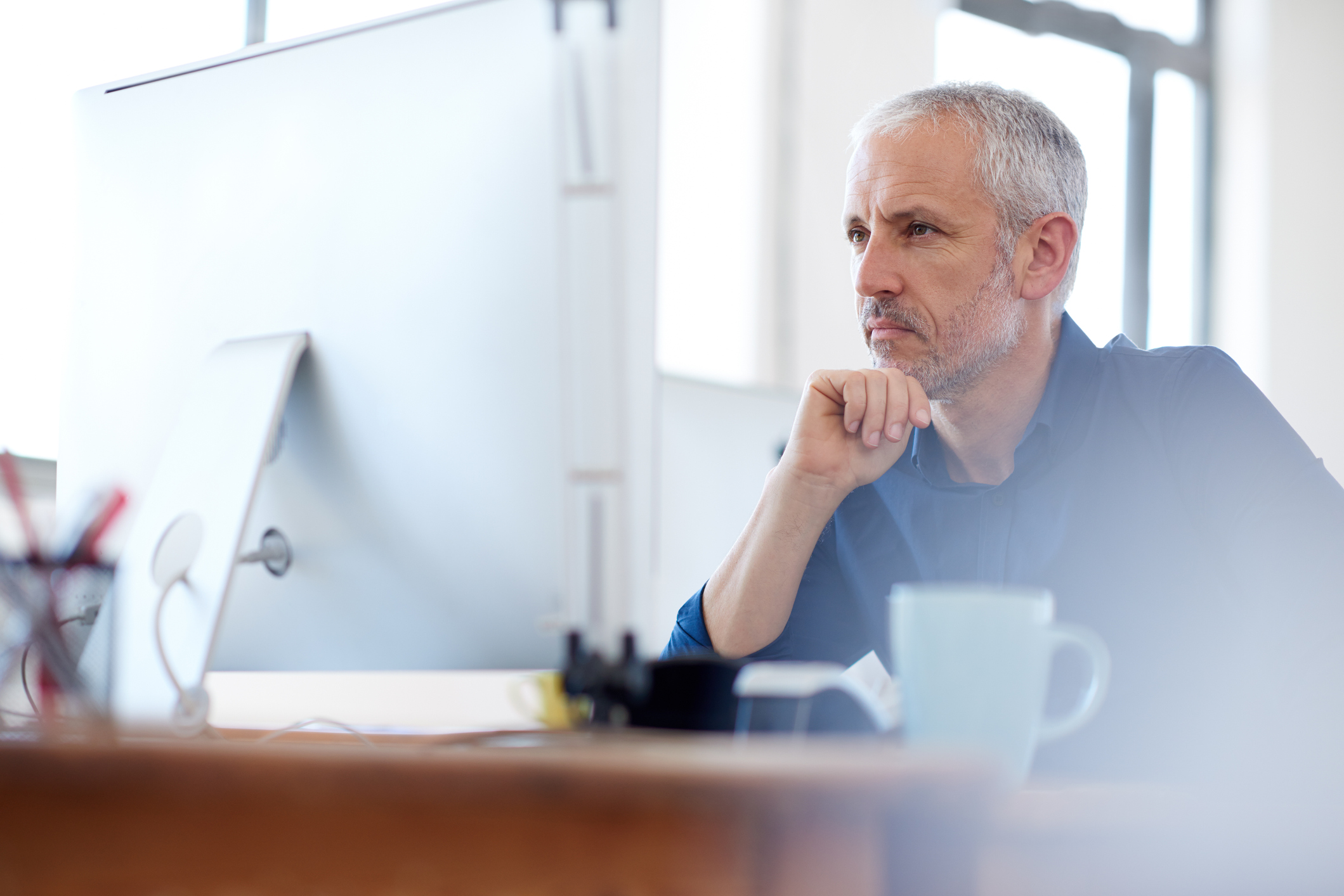 A person with a serious expression at a computer.