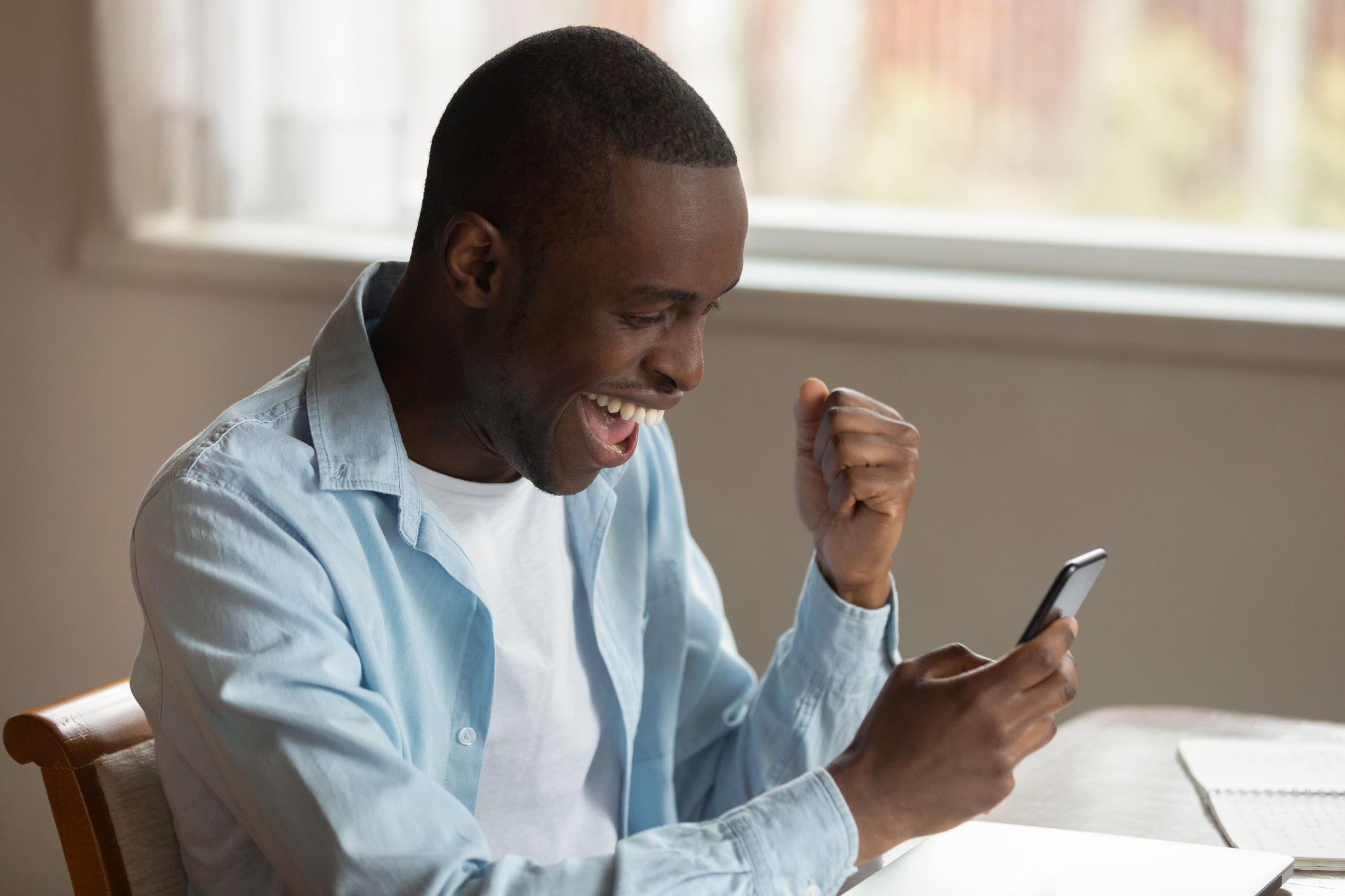 A person looking at their phone and cheering.