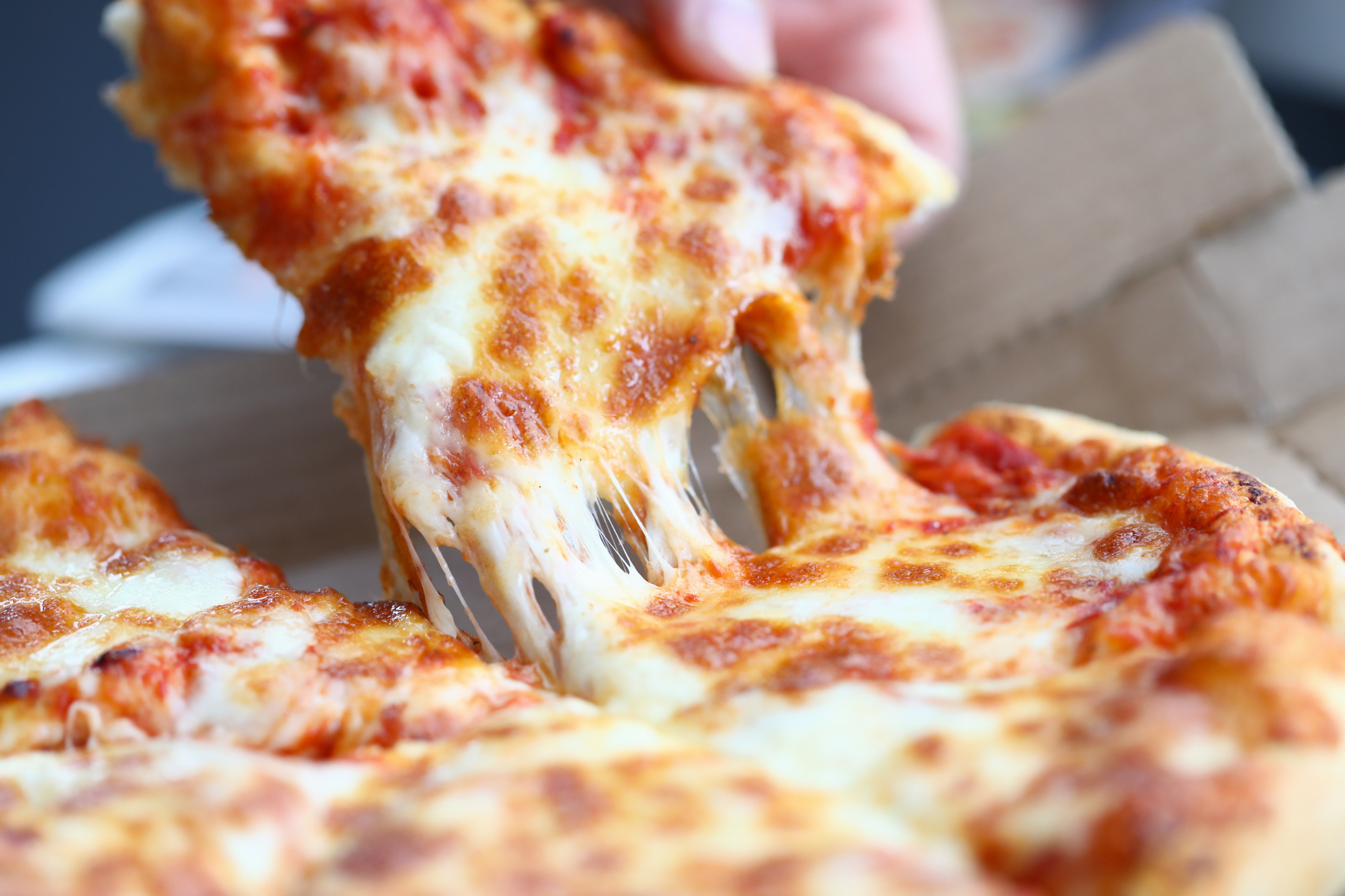 A slice of pizza being removed from a pie.