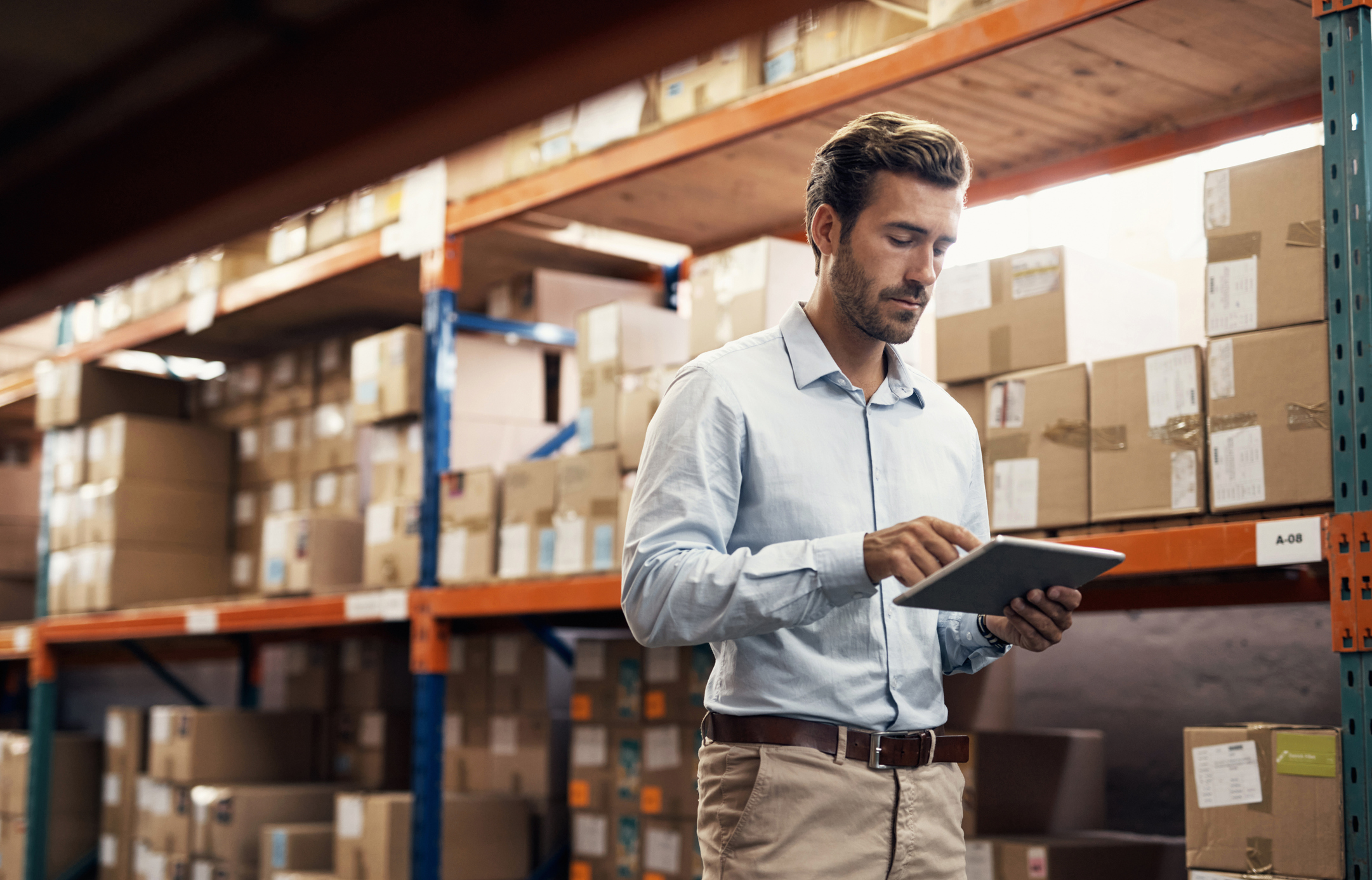 A person using a tablet in a warehouse.