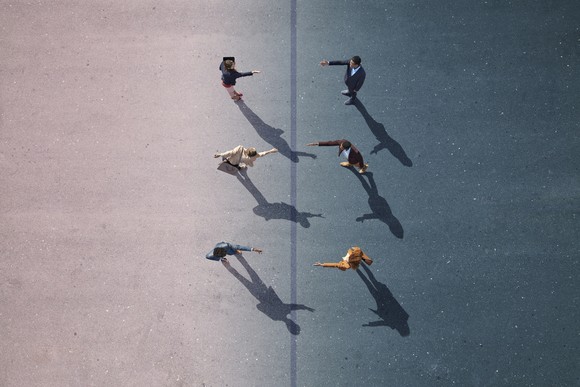 Three people holding out their hands to three people facing them.