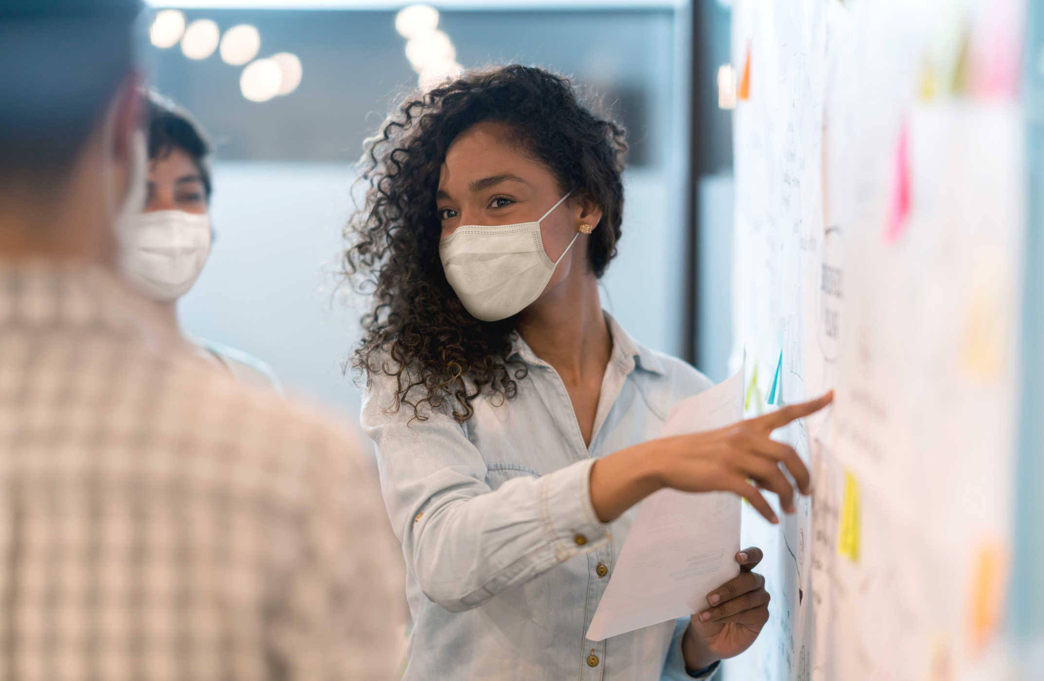 Team at work collaborating at a whiteboard with sticky notes.