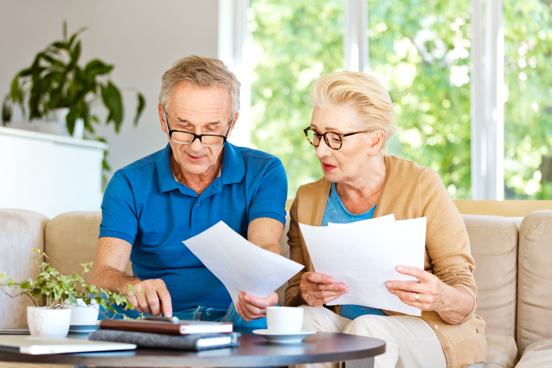 Two people with serious expressions holding documents.