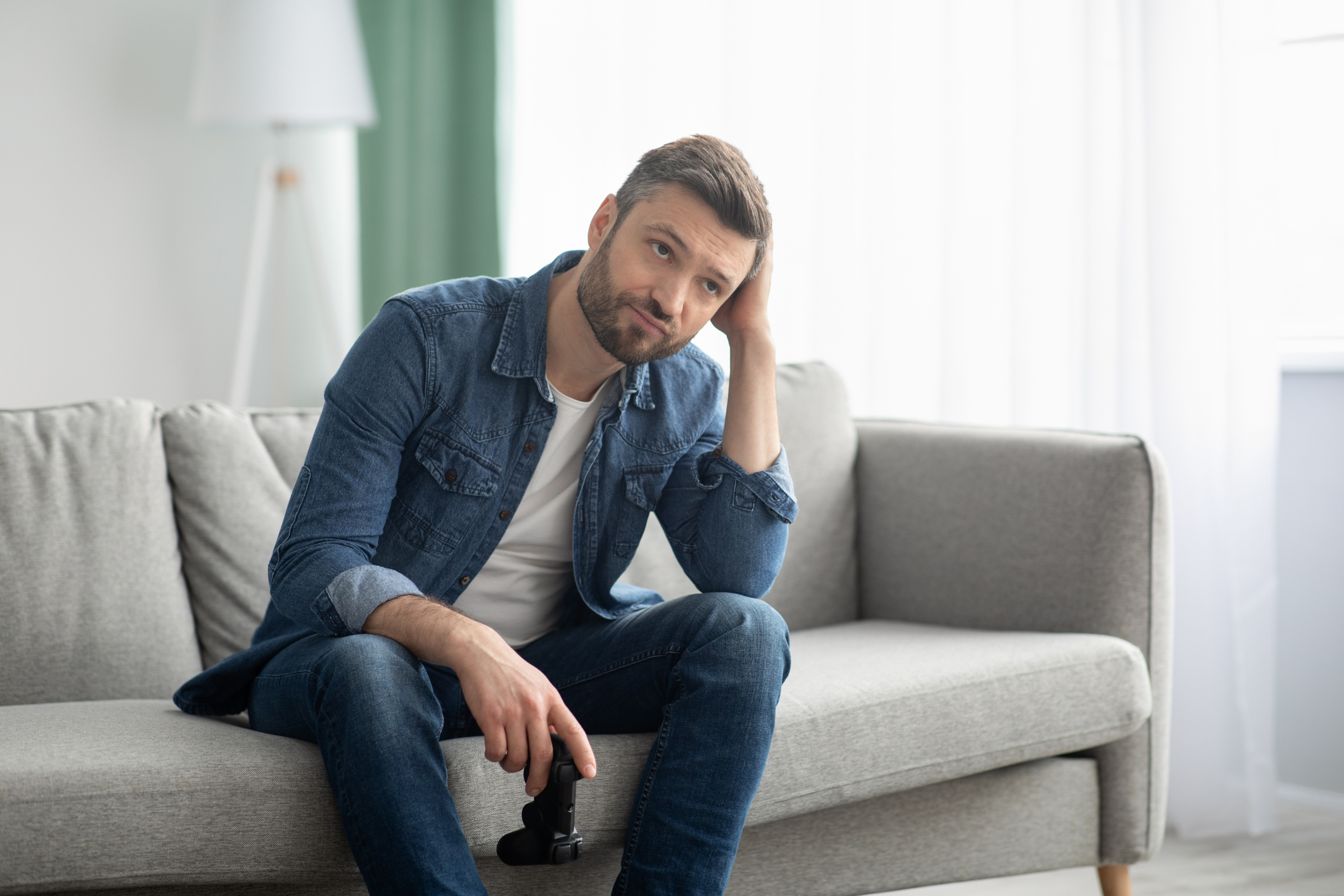 Frustrated gamer sitting on couch.
