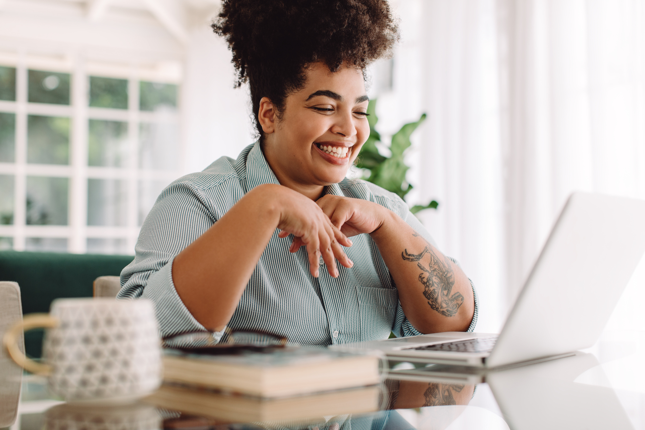 A person looking at a laptop and smiling.