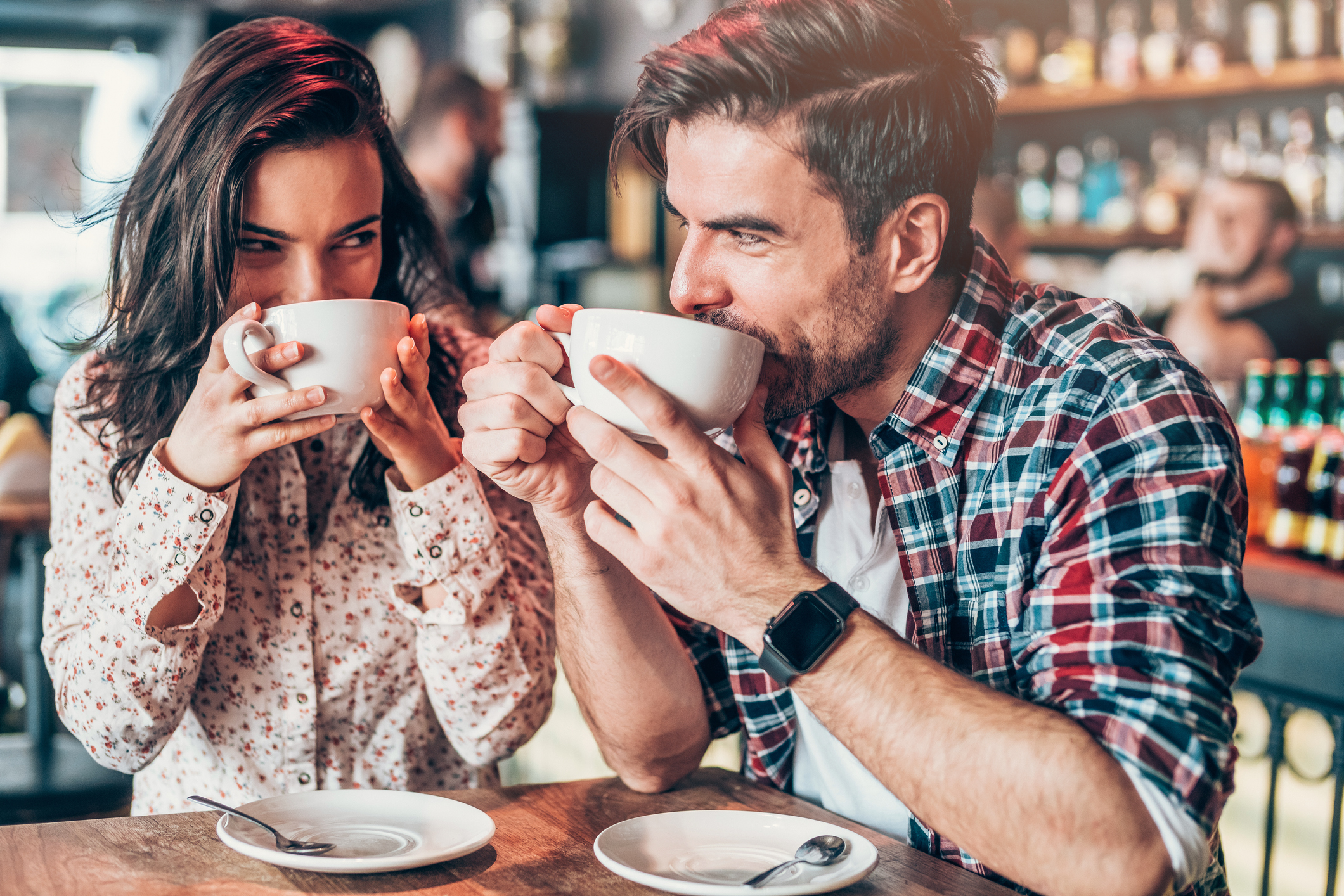 Couple drinking big cups of coffee.
