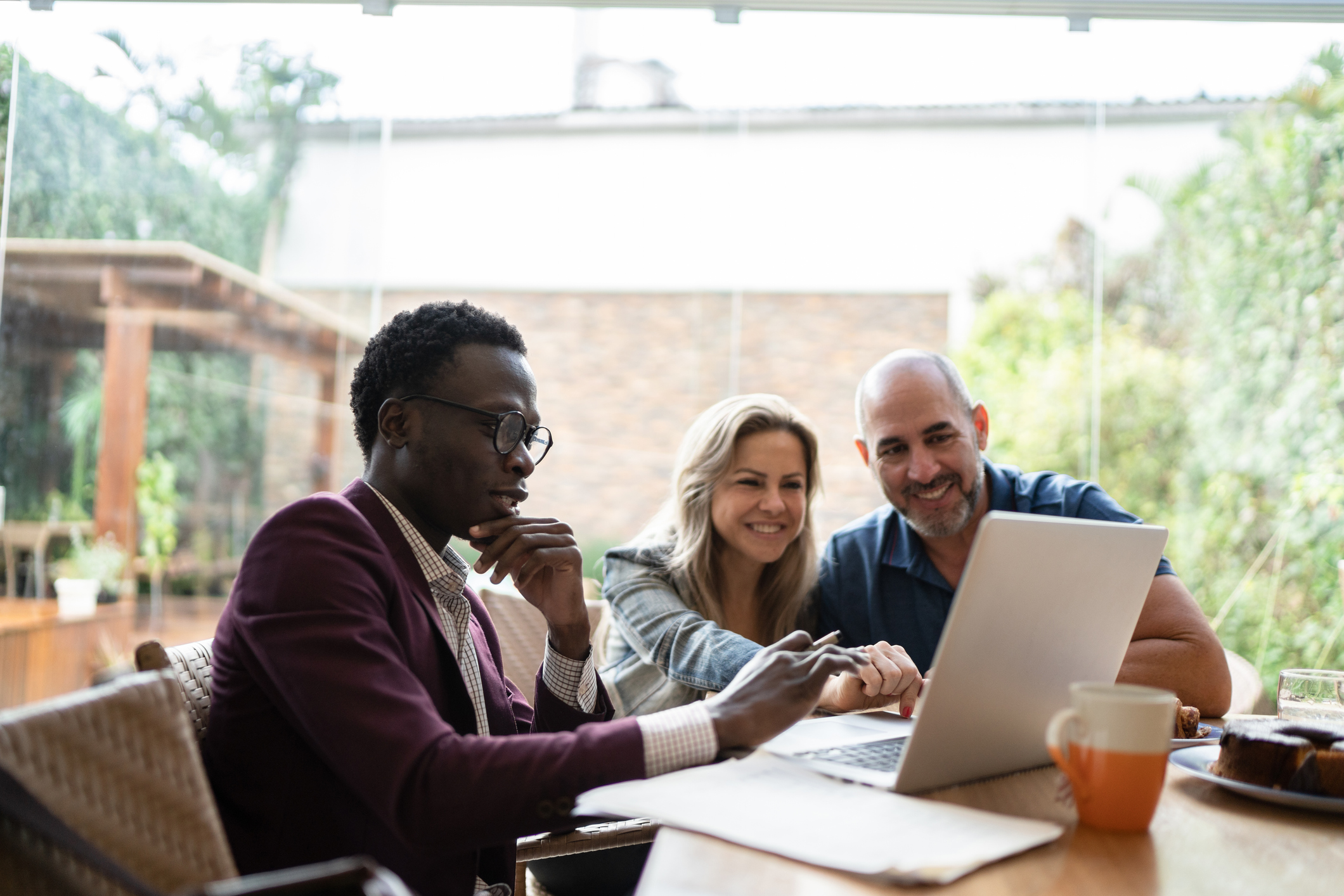 Three people reviewing something on a laptop.